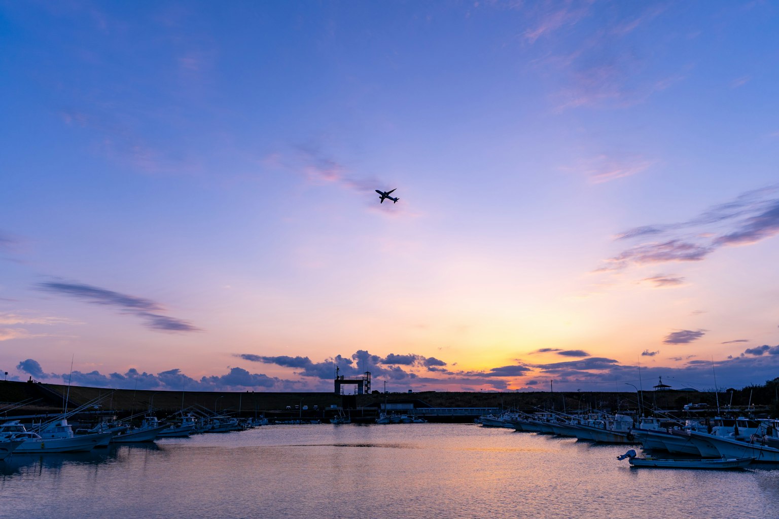 Schöner Sonnenuntergangshimmel über einem Hafen mit einem fliegenden Drohnen