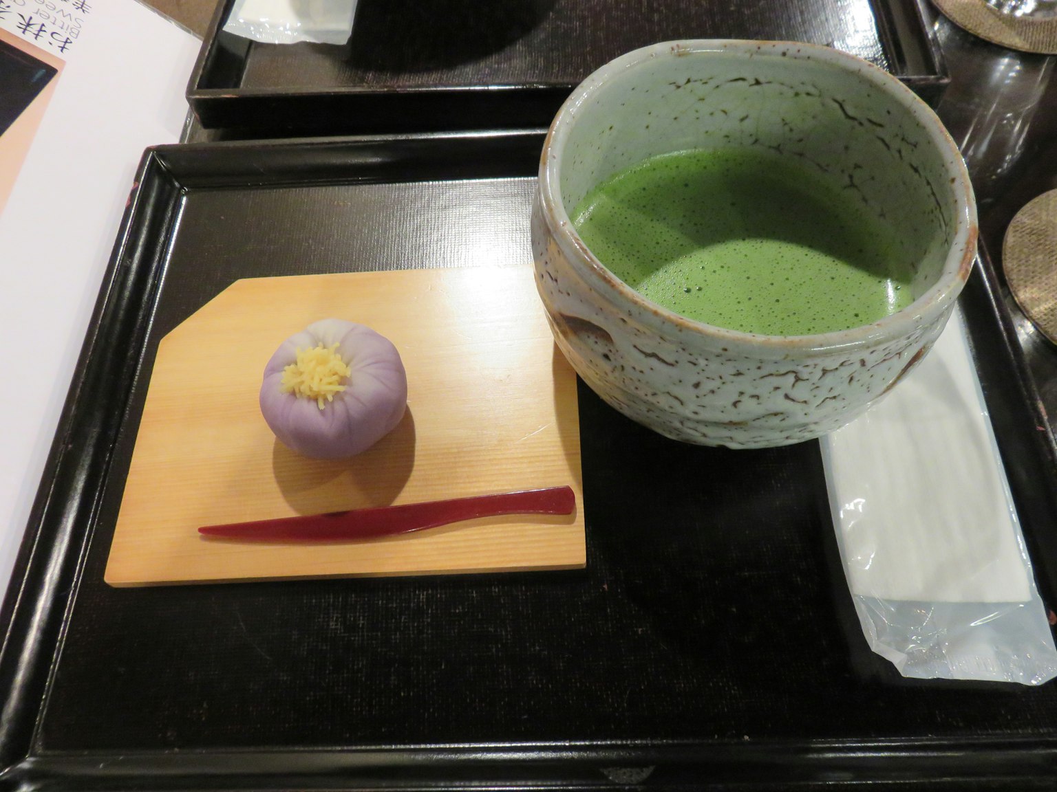 Thé matcha servi avec une douceur japonaise traditionnelle sur un plateau noir