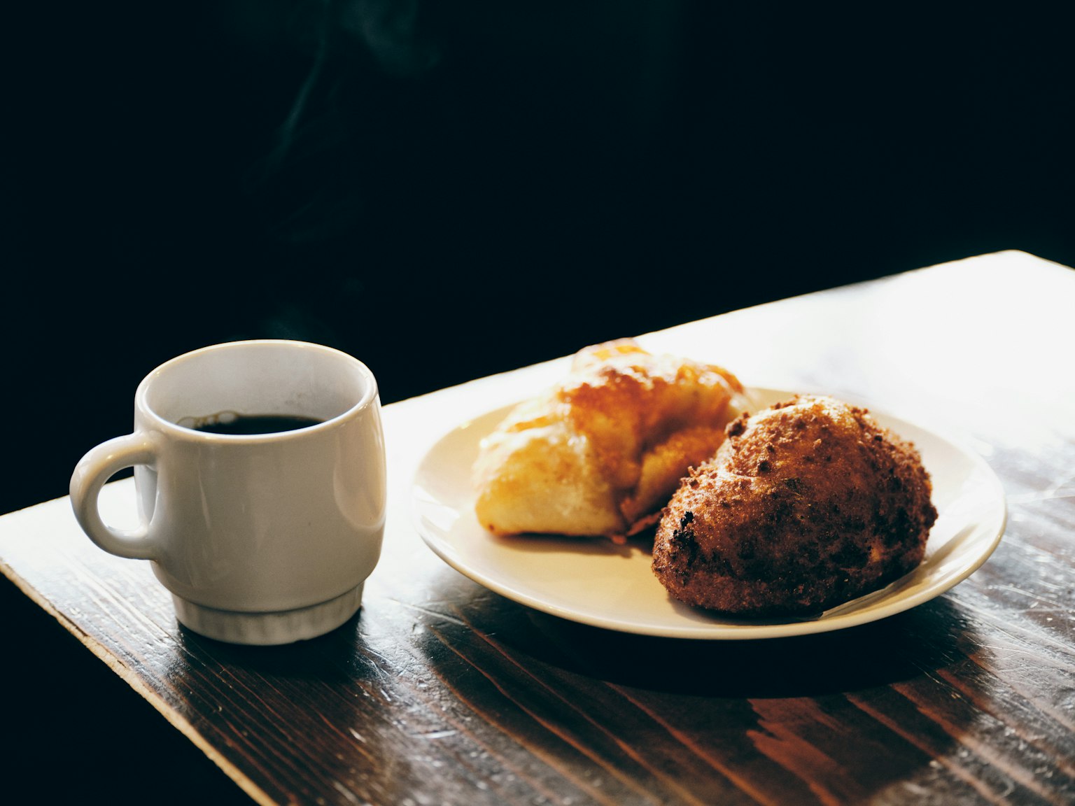 Une scène chaleureuse avec du café et des pâtisseries sur une table en bois