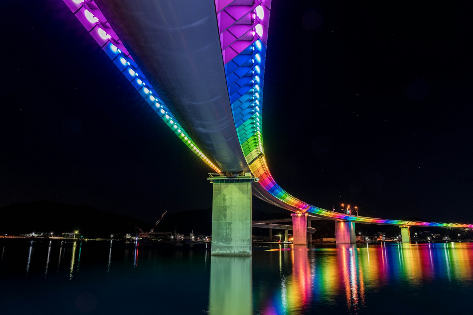 Ponte illuminato colorato visto da sotto di notte