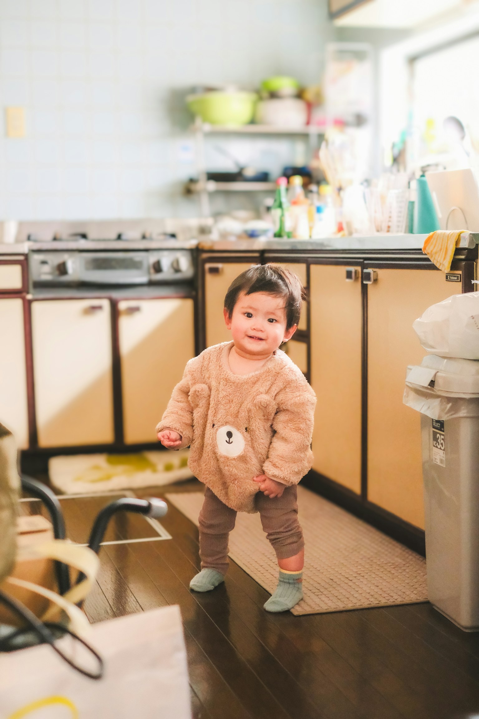 子供がキッチンで立っている様子 明るい色合いのインテリアと調理器具が見える