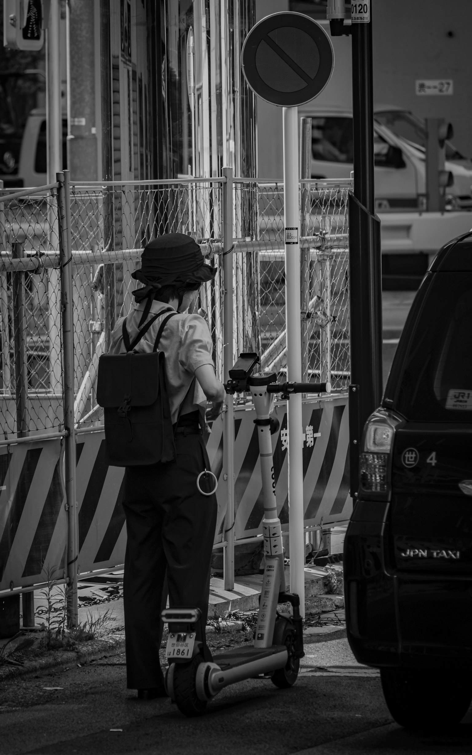 黒と白の街中で電動スクーターに立つ作業員の姿