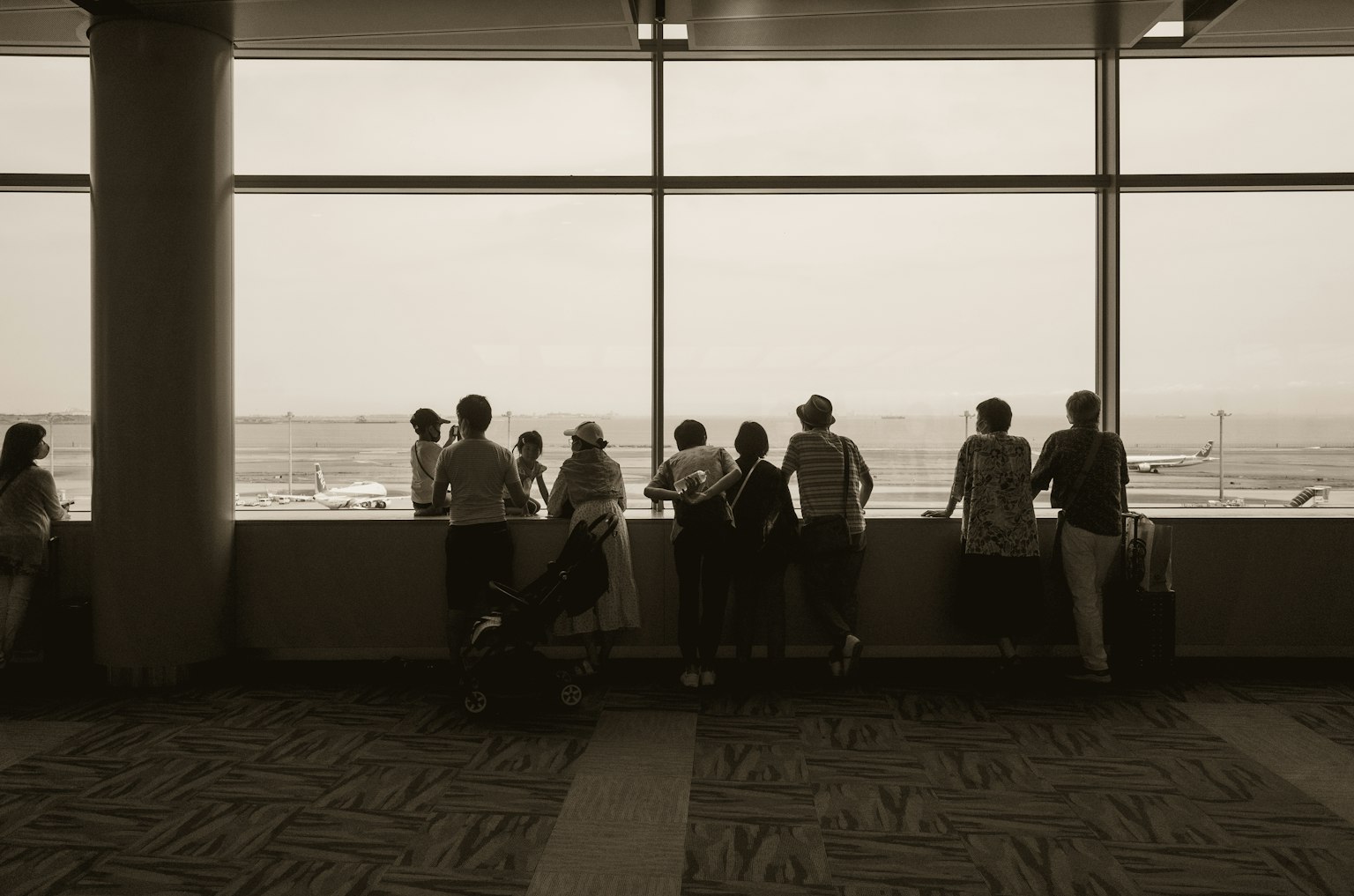 Silhouettes de personnes devant une fenêtre d'aéroport