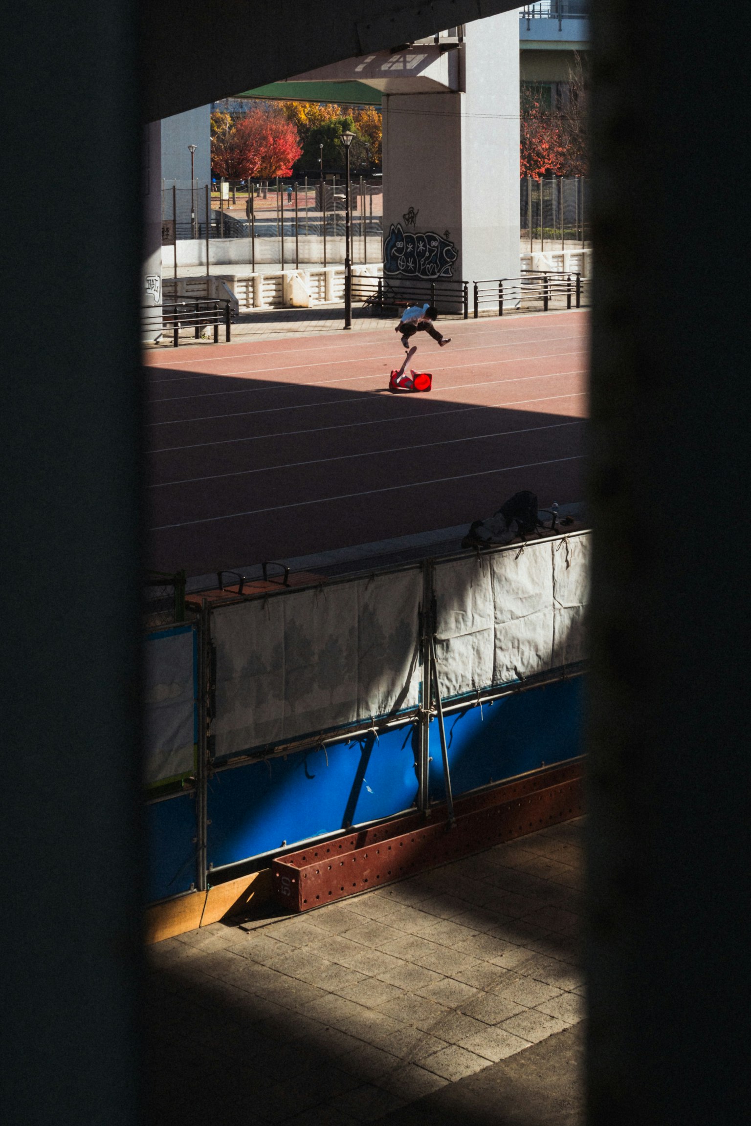 Eine Person in roter Kleidung, die im Park Skateboard fährt