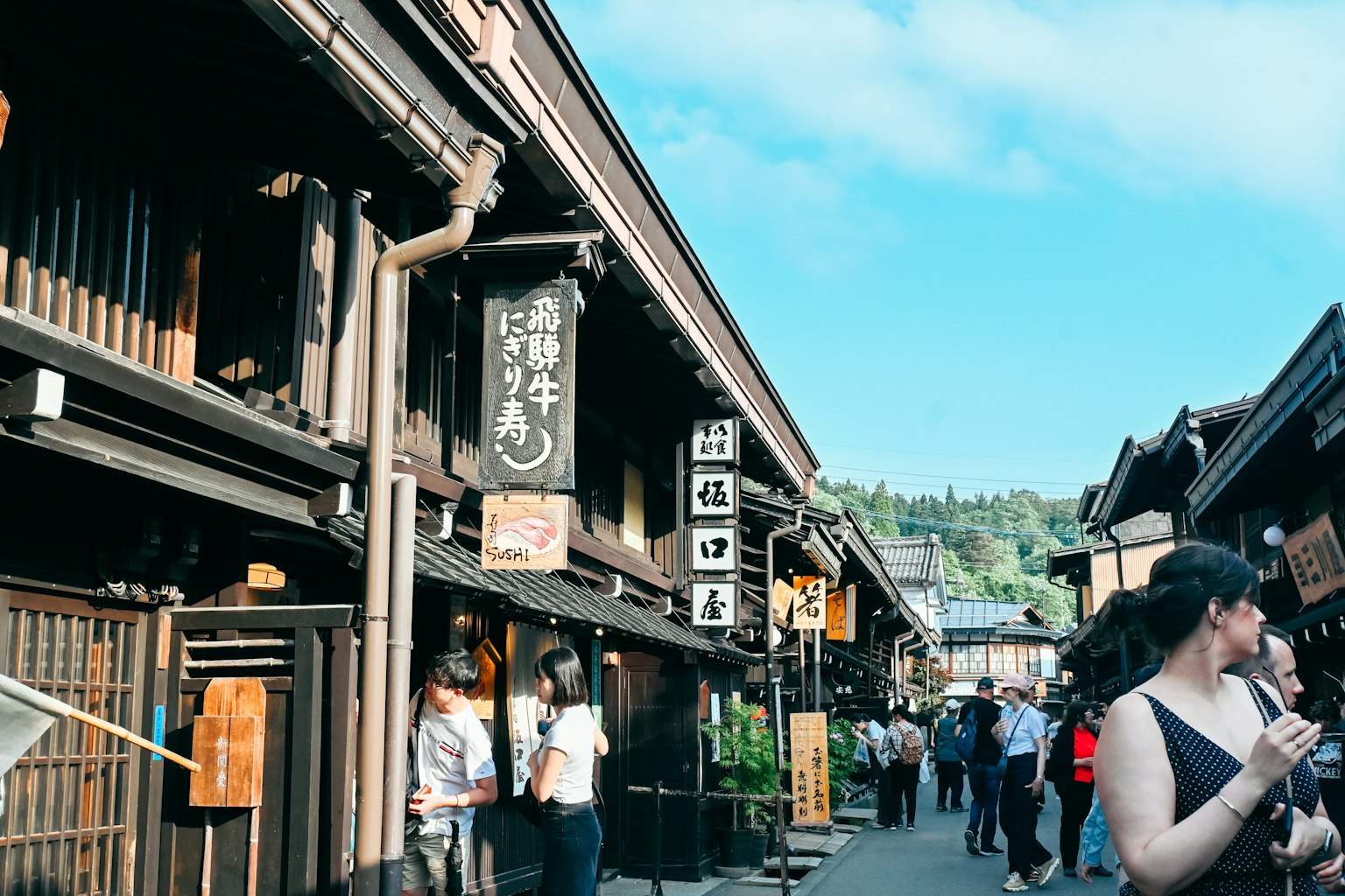 Calle japonesa histórica con edificios de madera tradicionales y turistas