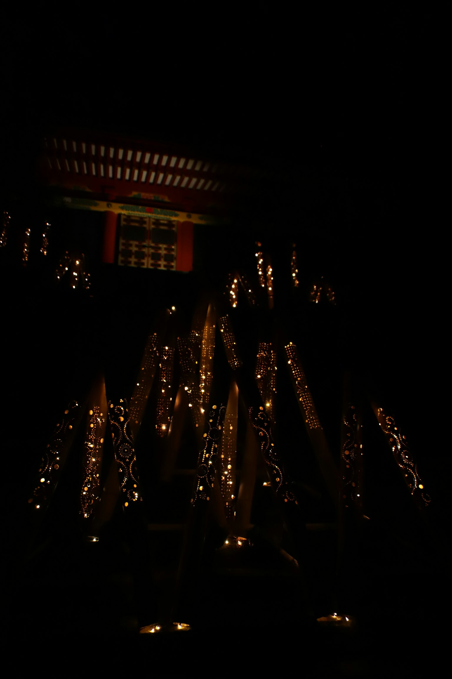 在黑暗背景中，許多小燈光照亮的神社