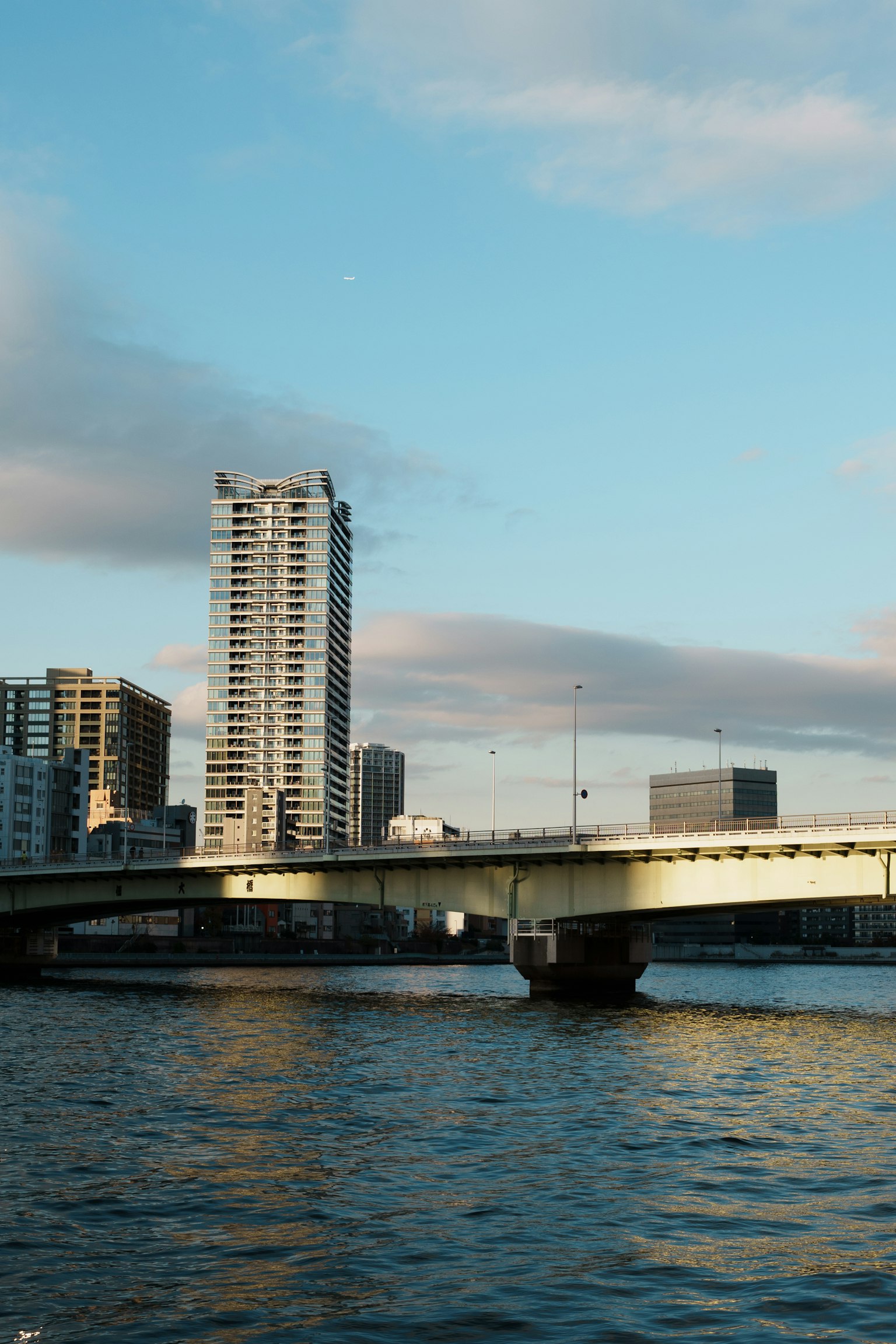 Vue d'un pont sur l'eau avec un bâtiment haut en arrière-plan