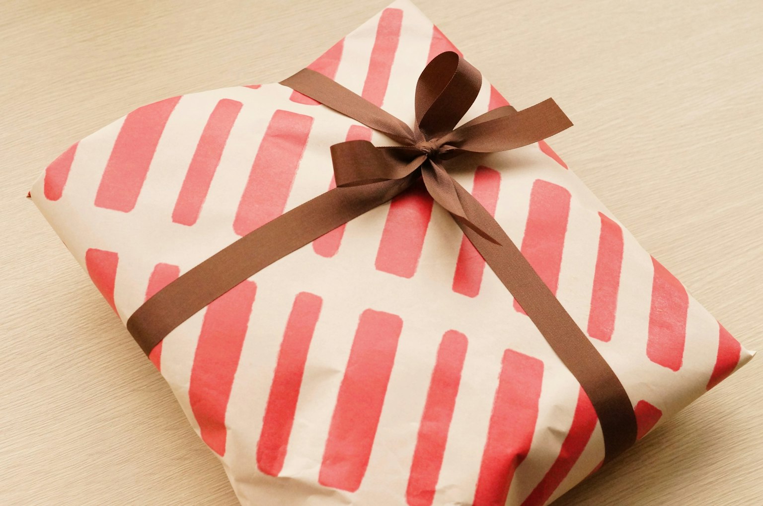 Geschenkbox eingewickelt in rot gestreiftem Papier mit braunem Band