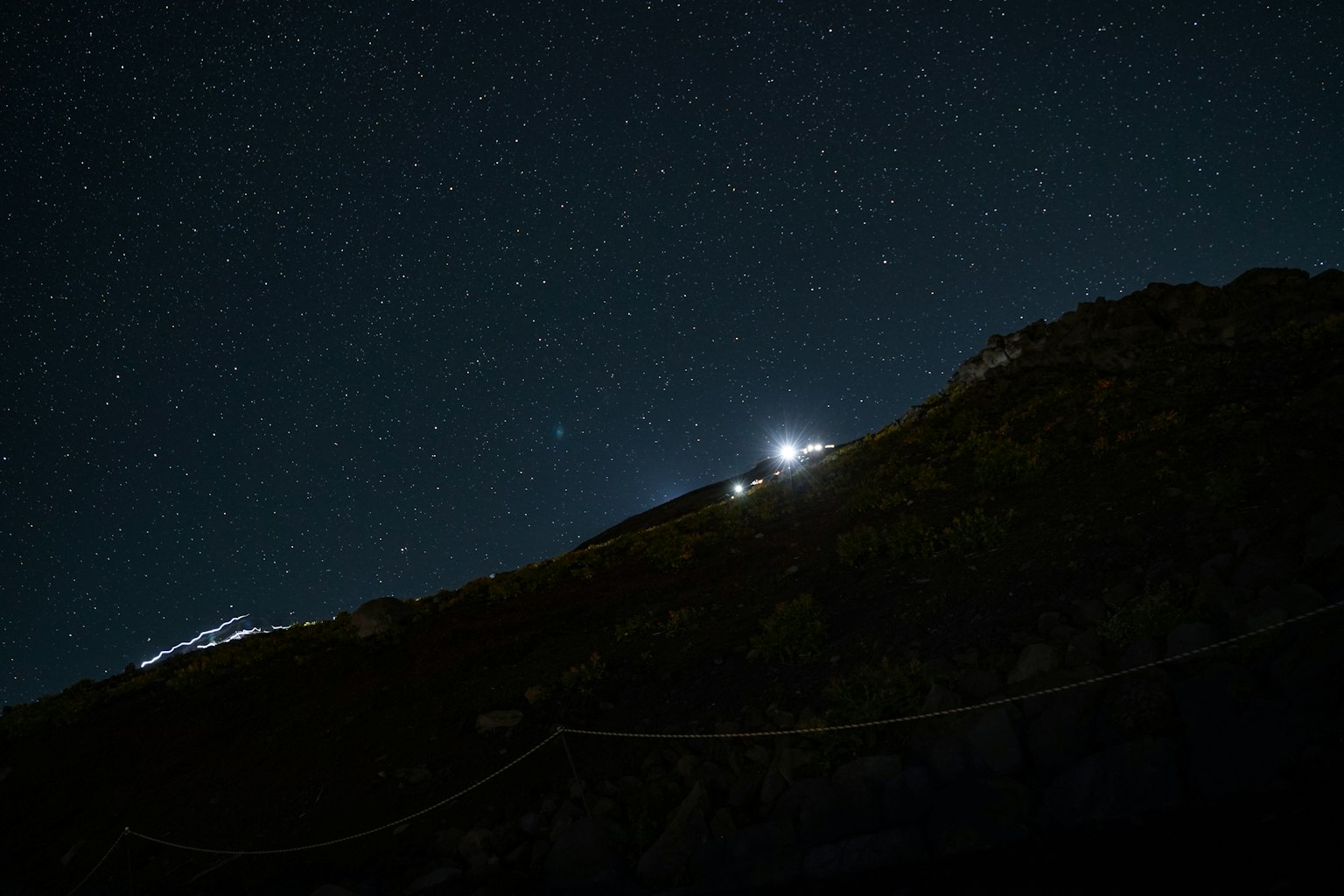 Cielo notturno pieno di stelle e silhouette di una montagna