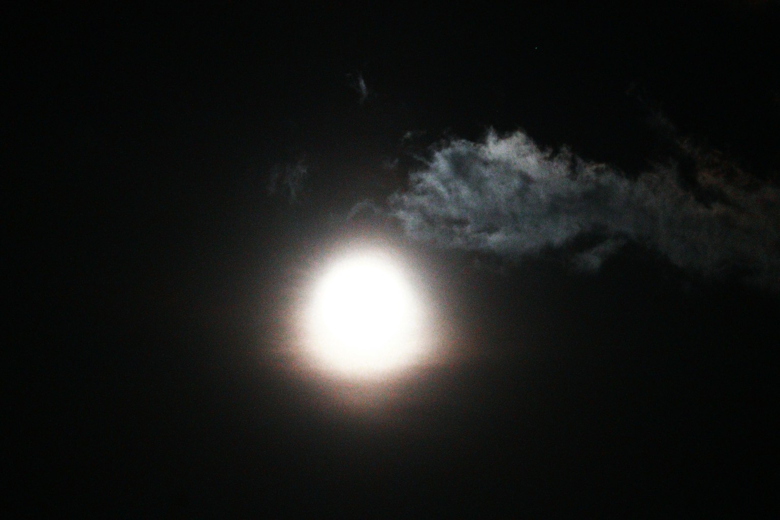 Luna luminosa che brilla attraverso le nuvole in un cielo scuro