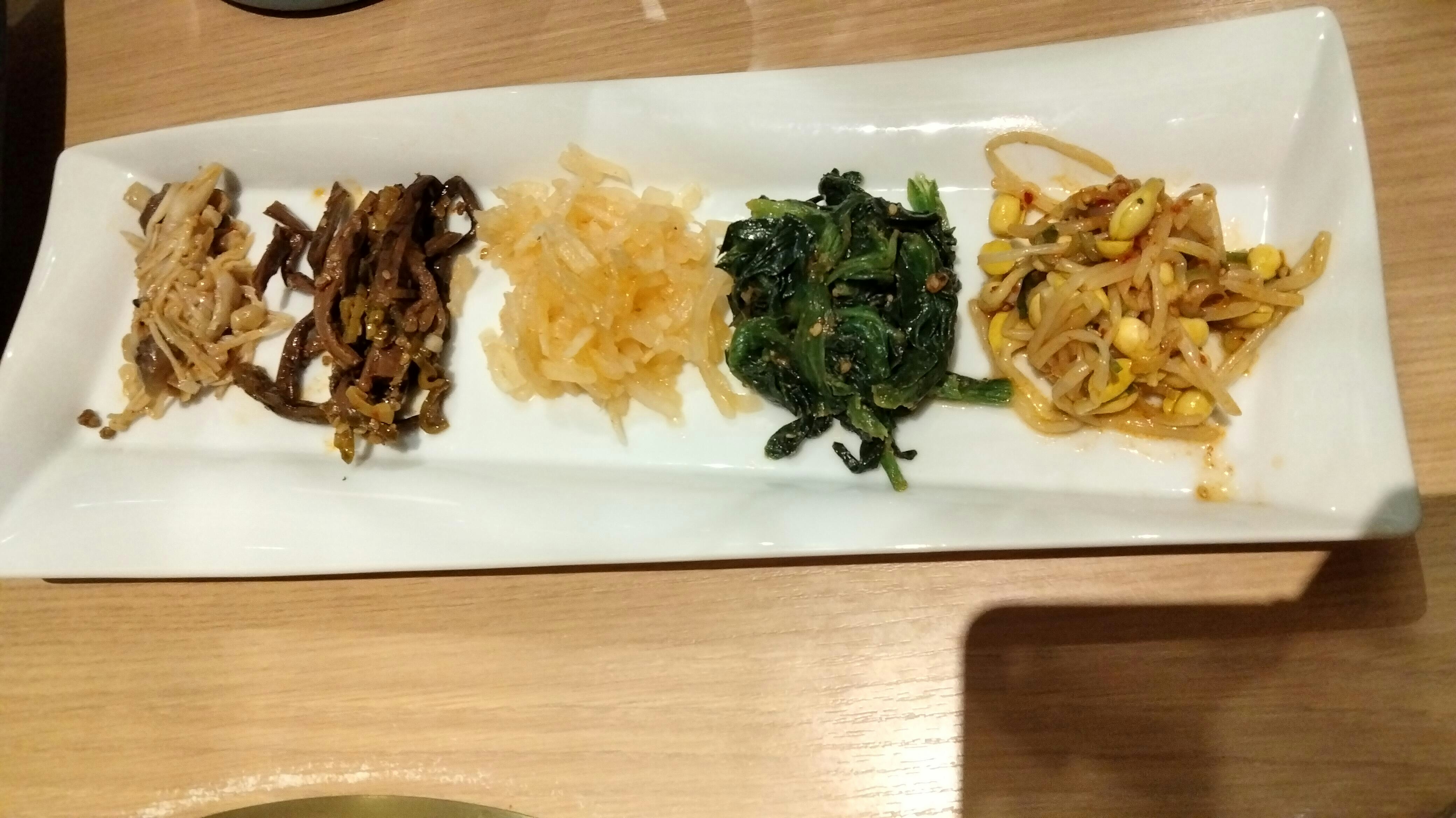 plato con surtido de comida japonesa sobre una mesa de madera