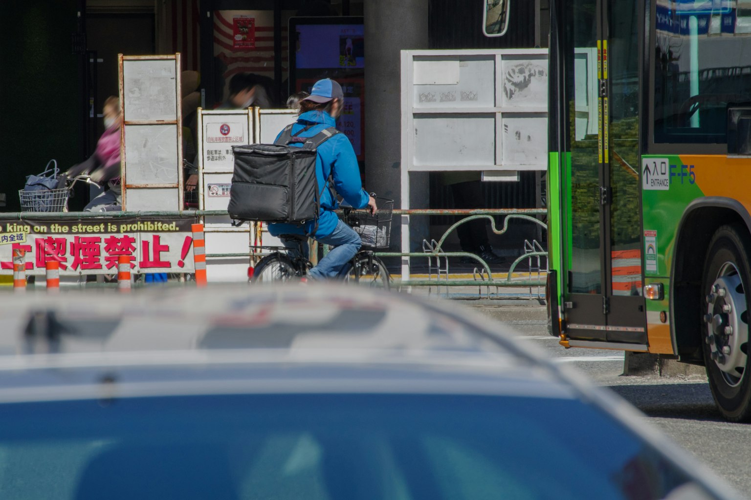 Ein Lieferant in blauer Jacke, der Fahrrad fährt
