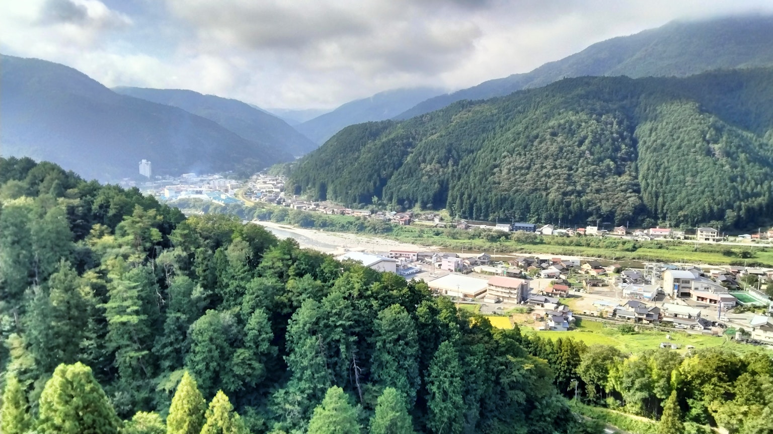 Scenic view of a valley surrounded by lush green mountains
