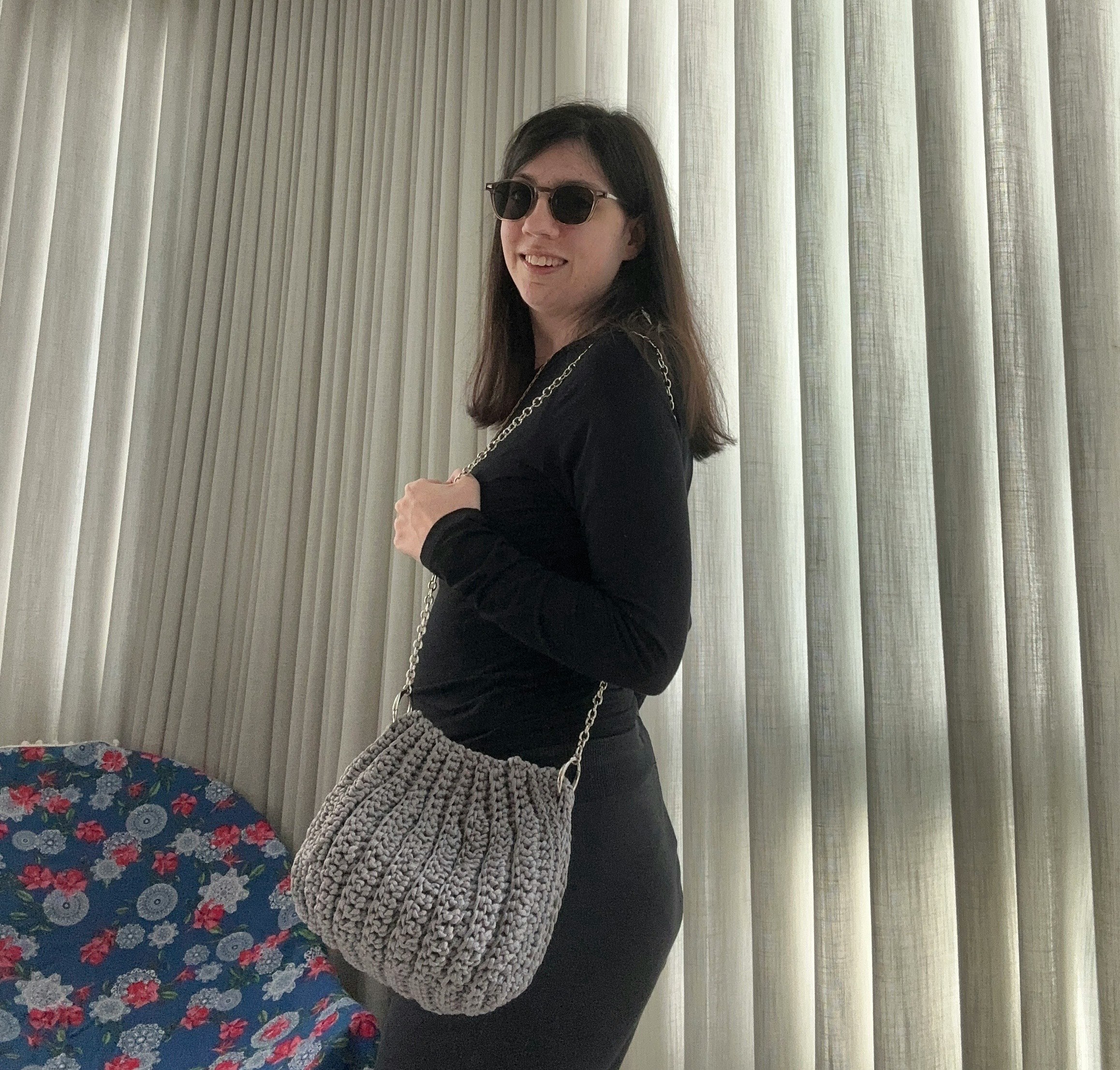 カーテンの前でサングラスをかけた女性のポーズ