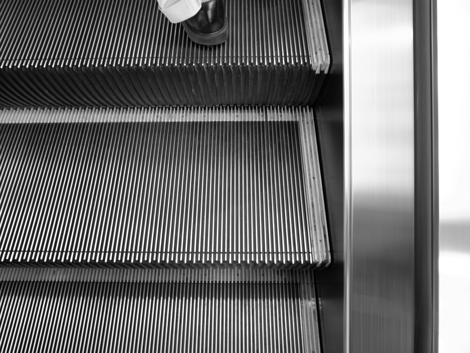 Gros plan sur les marches d'un escalator avec un pied humain