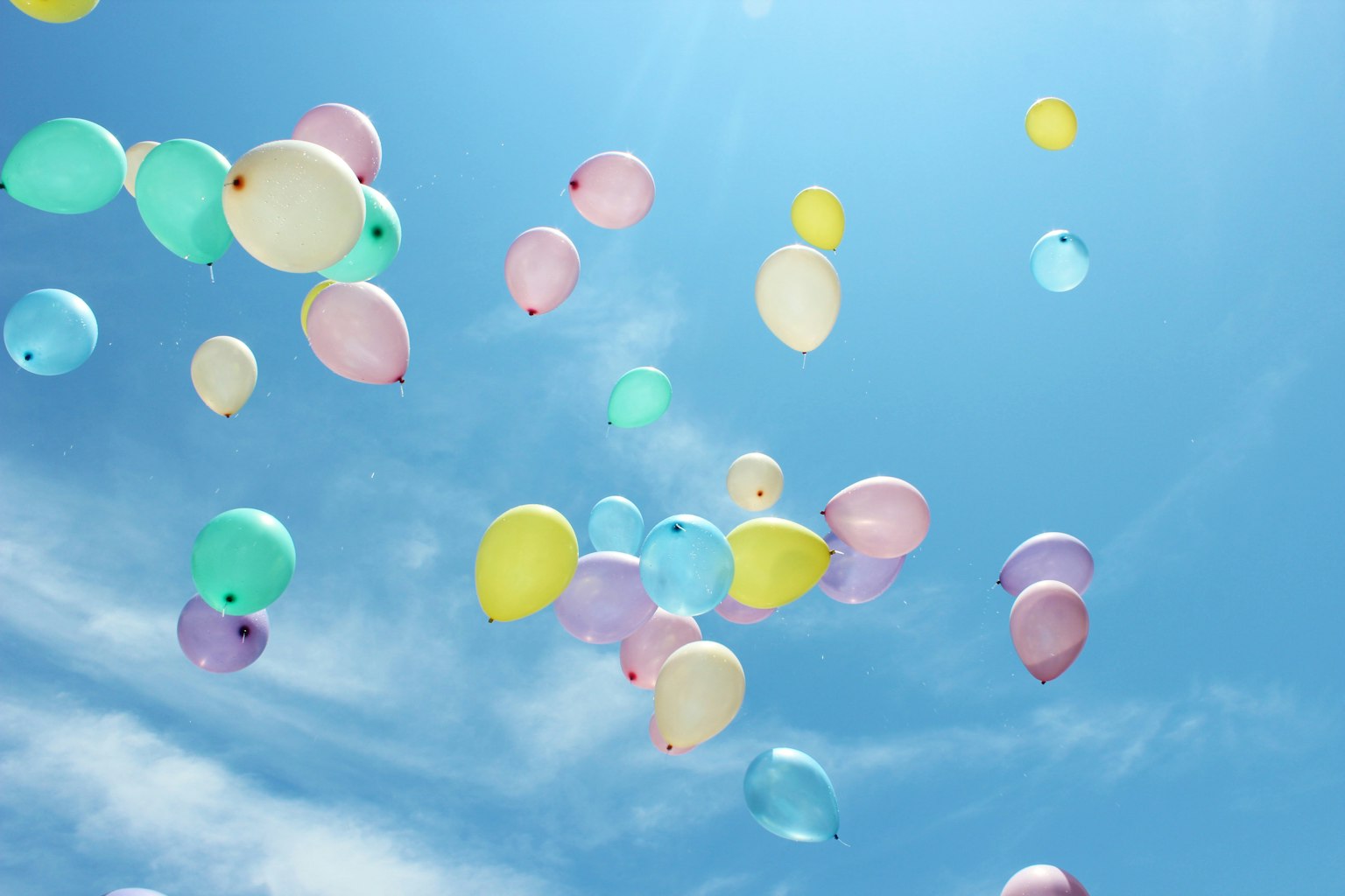 Des ballons colorés flottant dans un ciel bleu