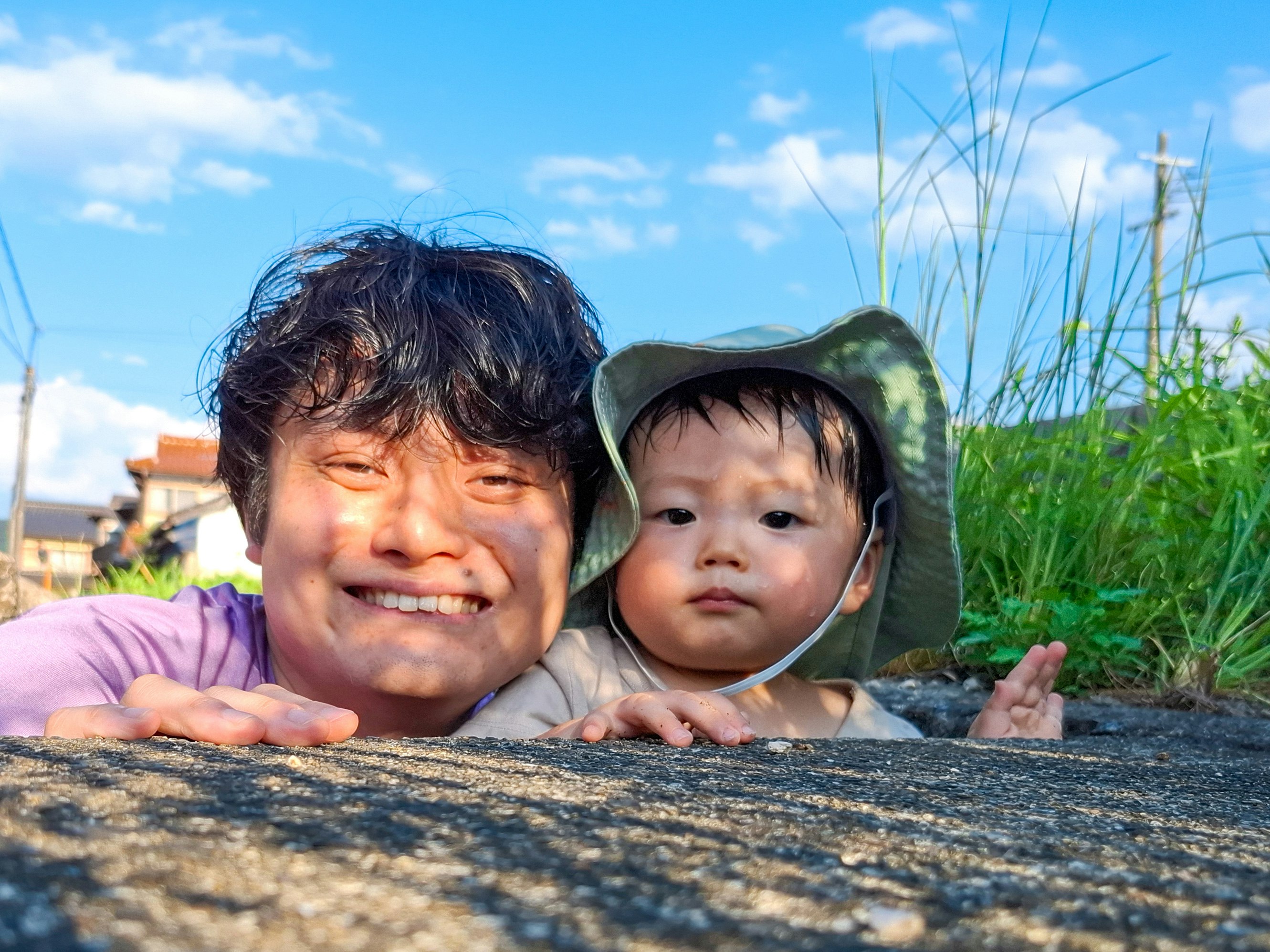 草地水边父亲与婴儿依偎