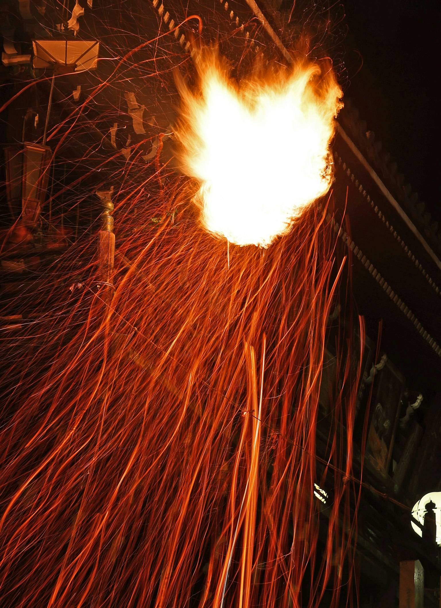 ประกายไฟและเปลวไฟสว่างที่พุ่งออกมาจากพื้นหลังมืด