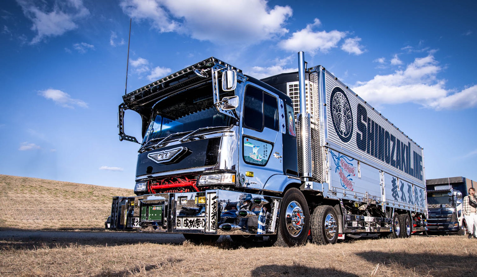 Camion blu lucido parcheggiato sotto un cielo azzurro
