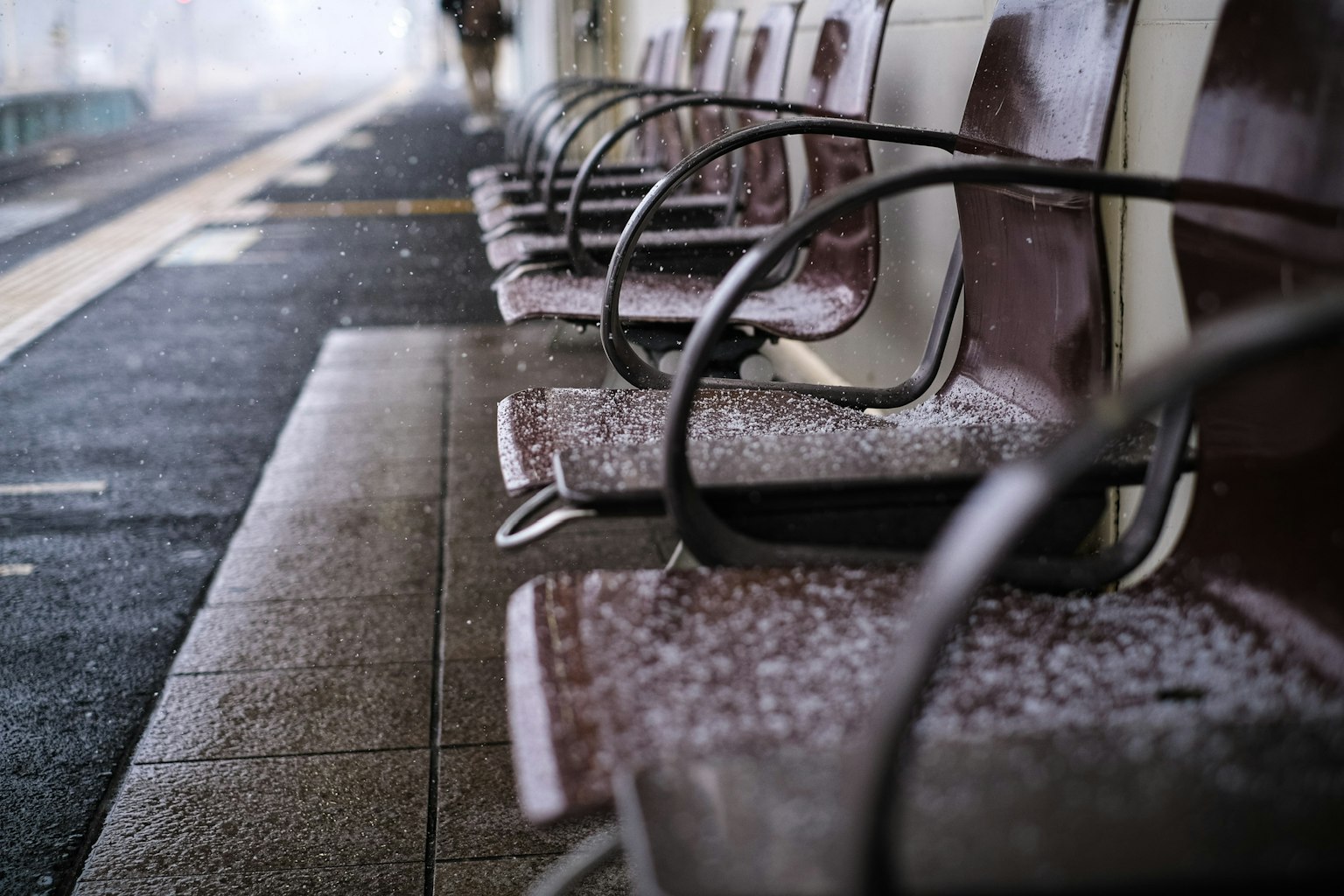 Bancos cubiertos de nieve en una plataforma de tren