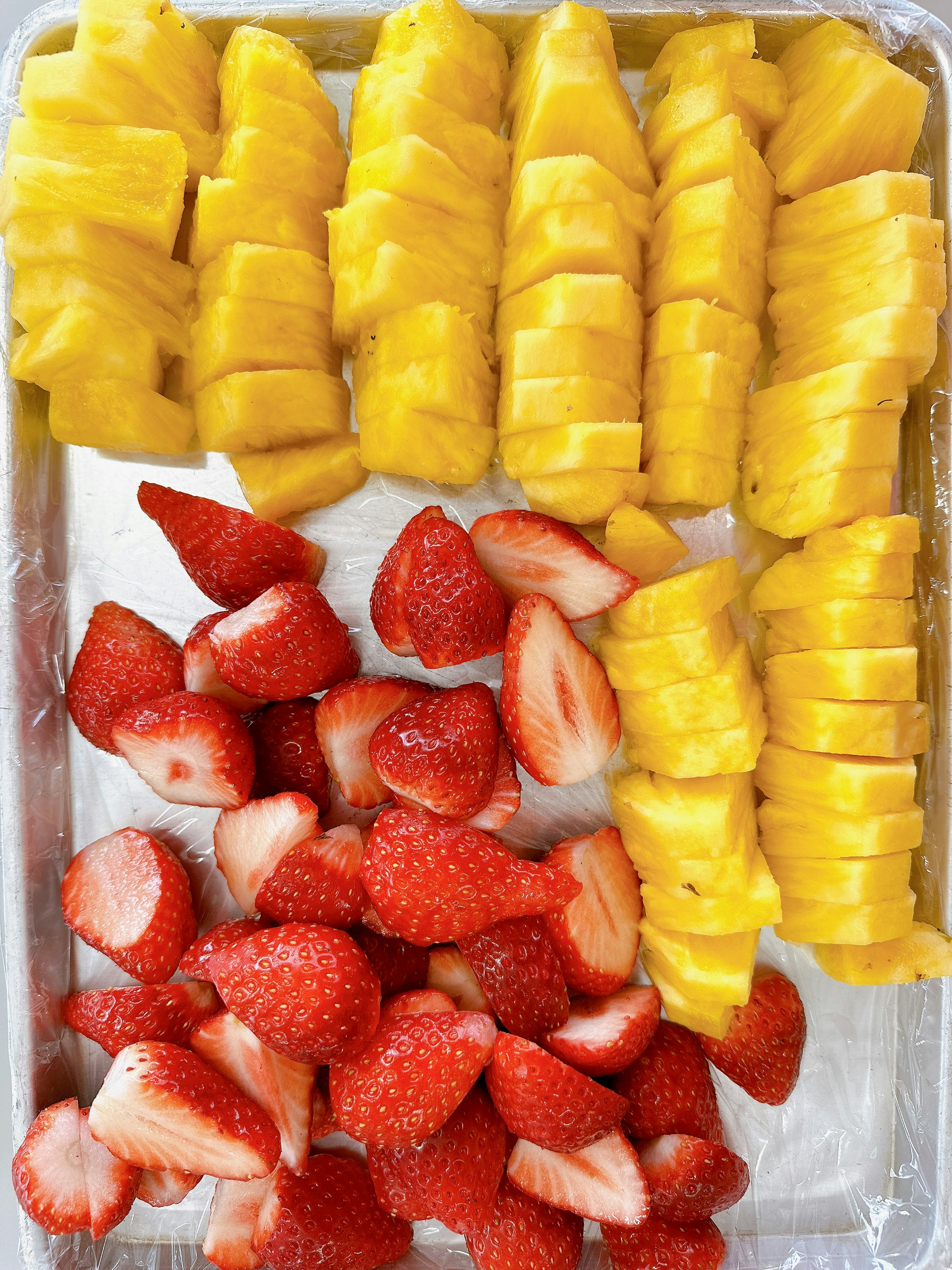 geschnittene Erdbeeren und Mango auf einem Tablett
