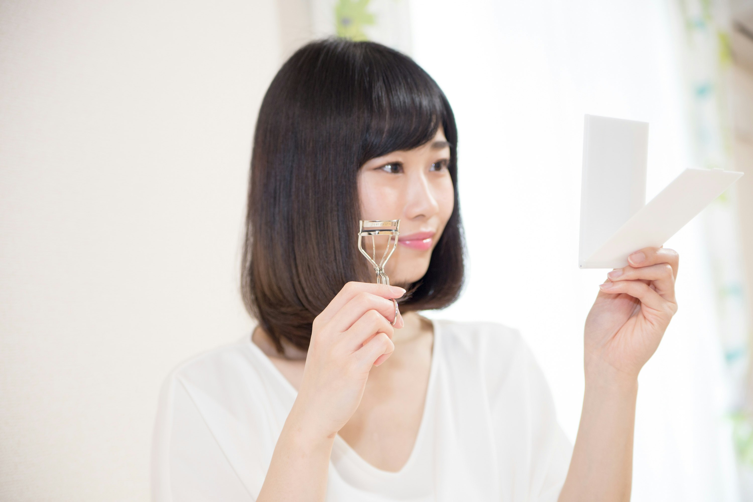 穿白袍的女性手持美容儀