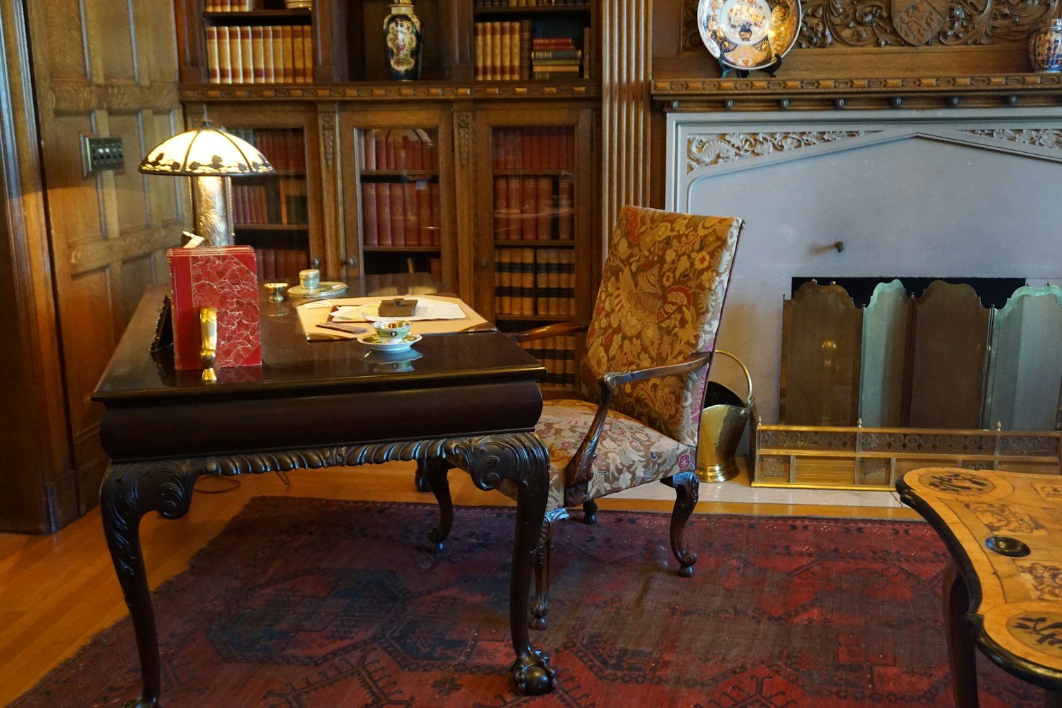Luxuriöser Studienraum mit Holzregalen und einem verzierten Schreibtisch