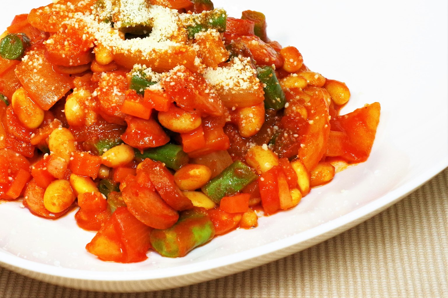 Gericht mit Tomatensauce und Gemüse, garniert mit Parmesankäse