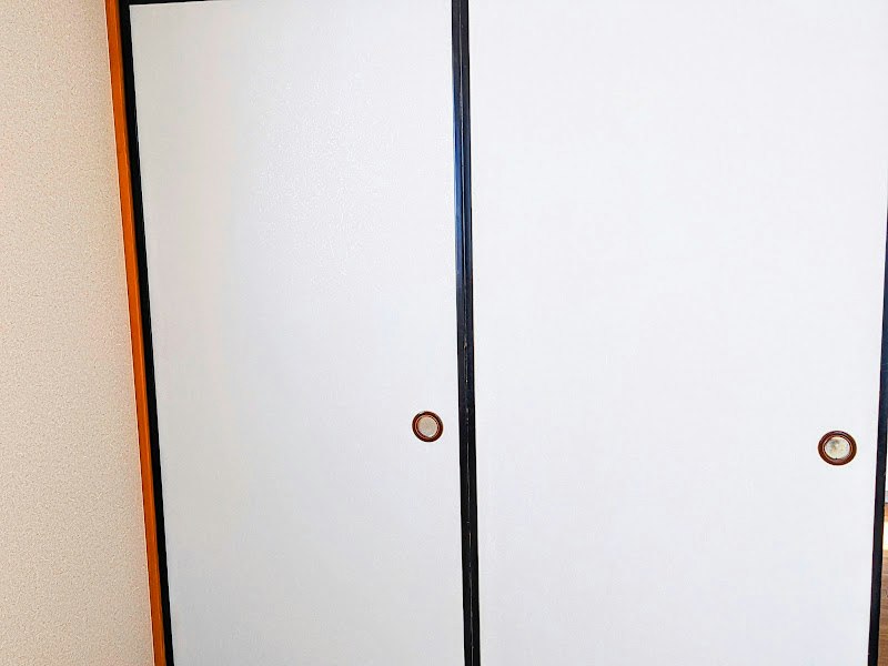 Close-up of a white wall and black-framed door