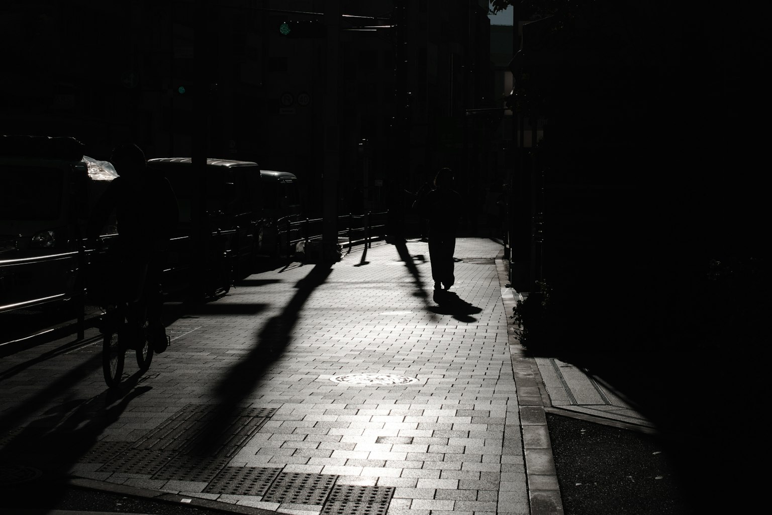 Silhouette orang berjalan di jalan yang redup