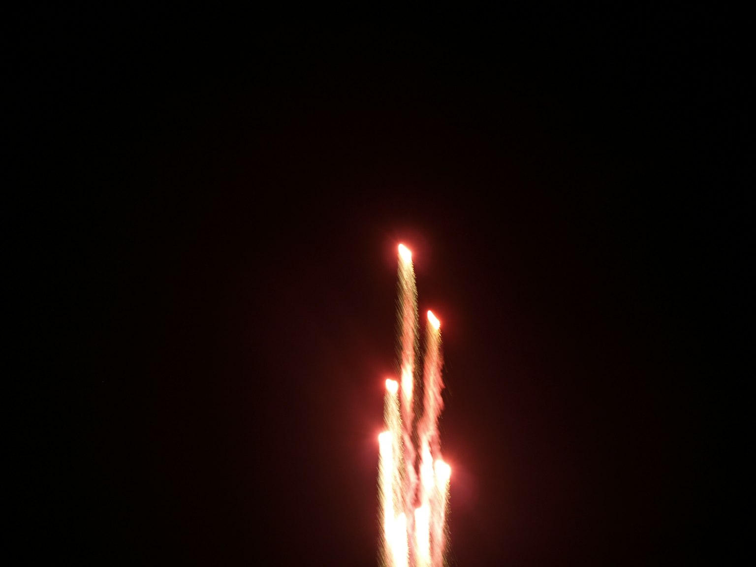 Fireworks shooting upward against a dark background