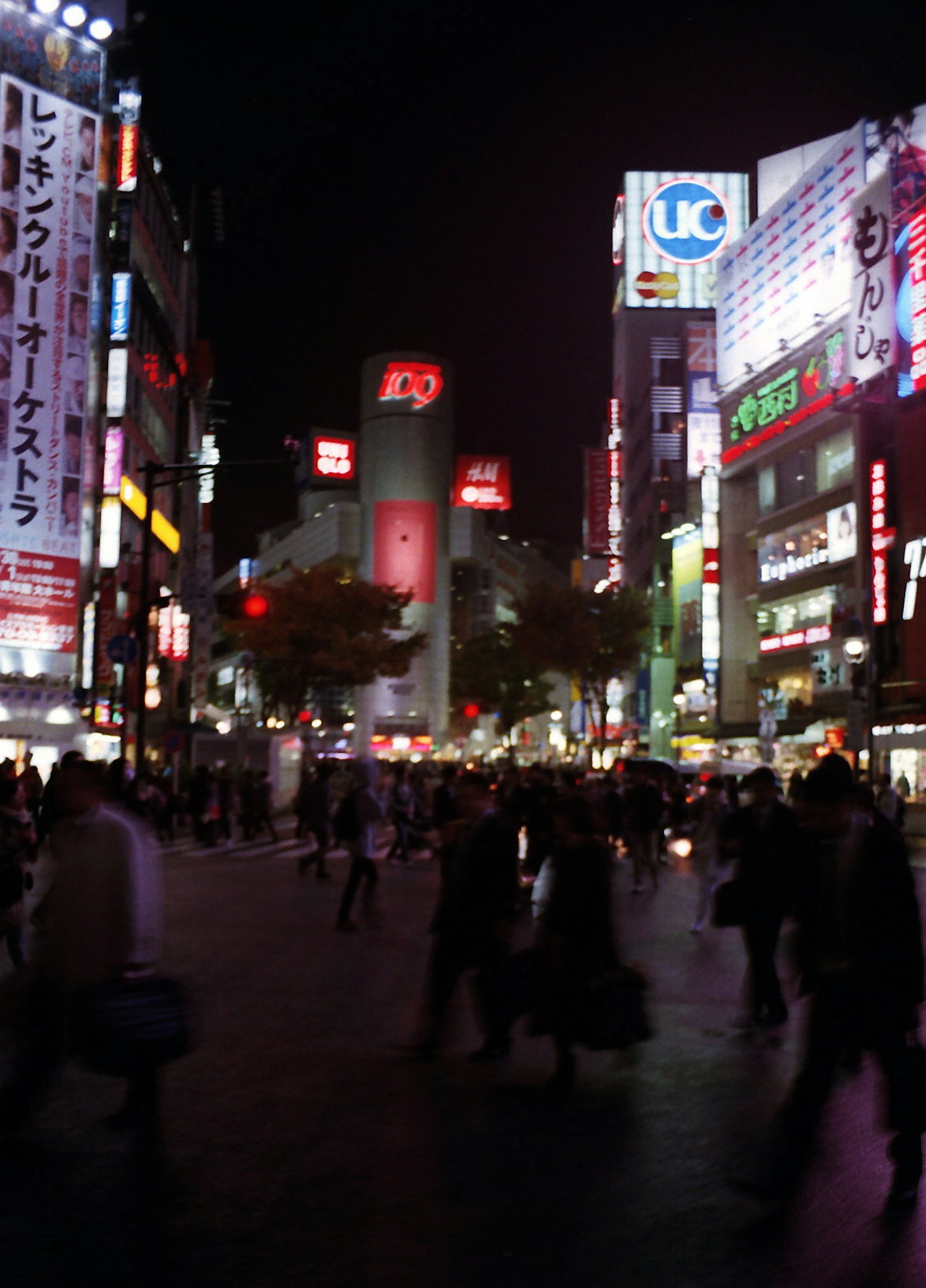 Busy Shibuya Crossing at night with vibrant neon lights