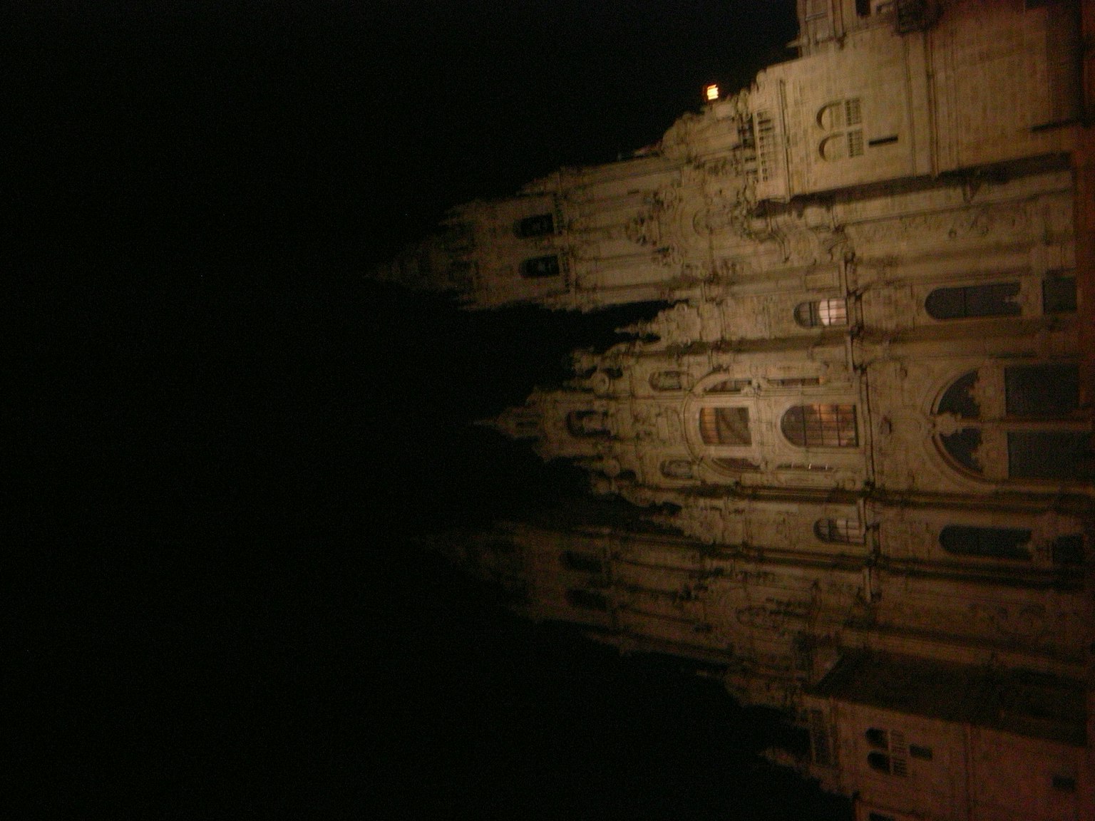 Escena nocturna con el reflejo de un edificio místico en la oscuridad