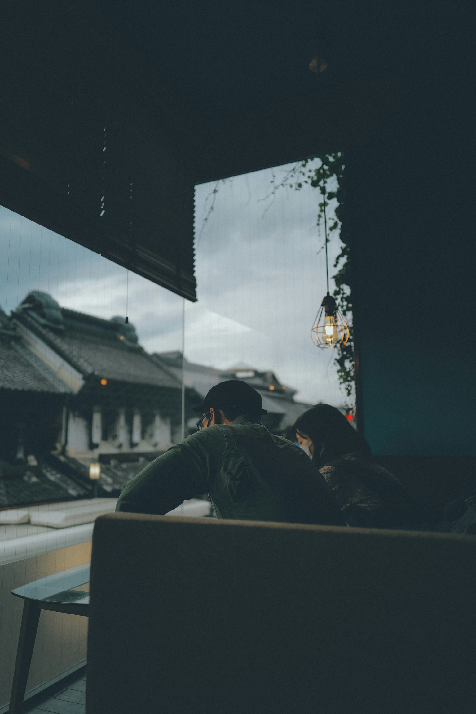 窗边坐着的两个人的轮廓与阴天的景象