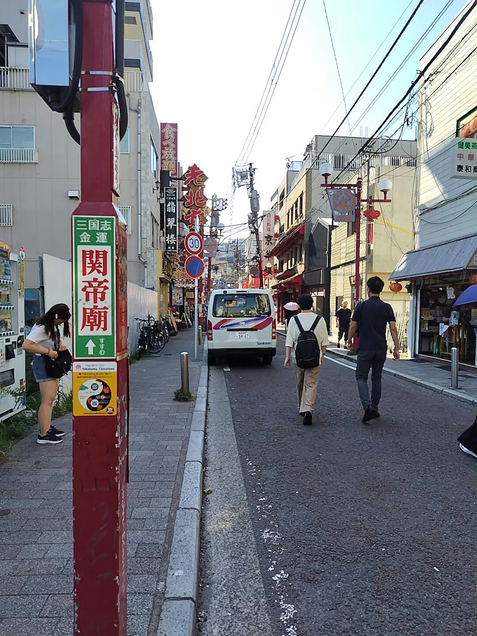 ฉากถนนที่มีผู้คนเดินและรถยนต์