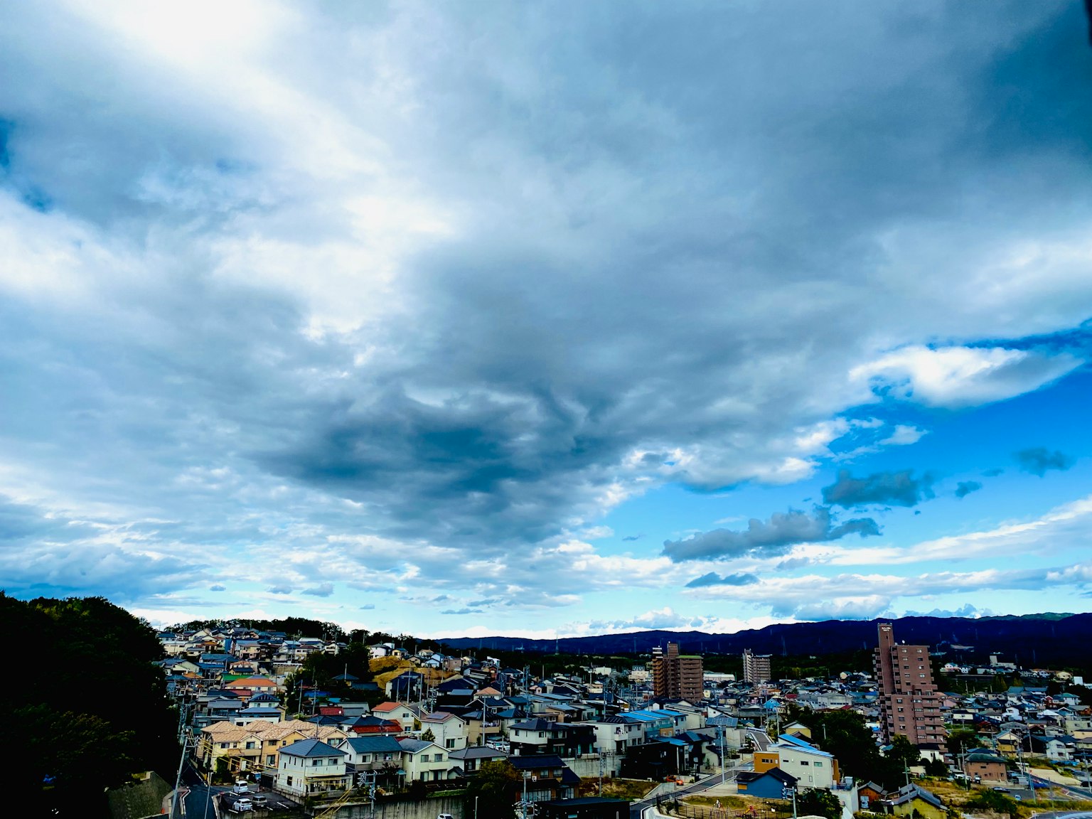 Eine Stadtansicht mit bunten Häusern unter einem blauen Himmel mit Wolken