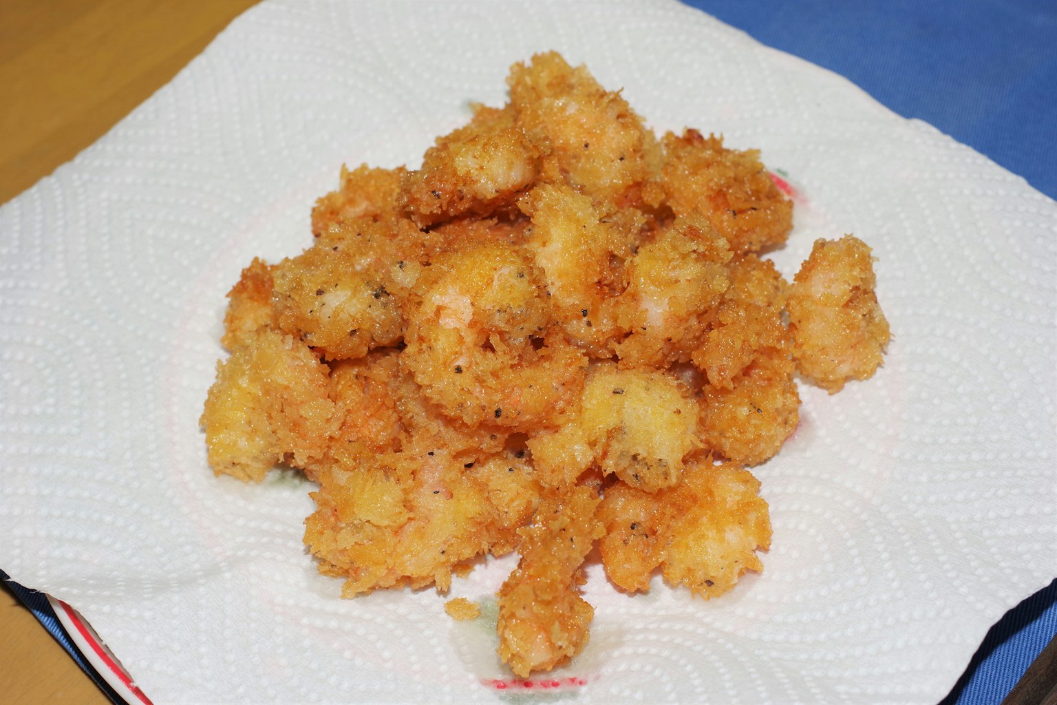 กองกุ้งชุบแป้งทอดวางอยู่บนกระดาษเช็ดหน้า