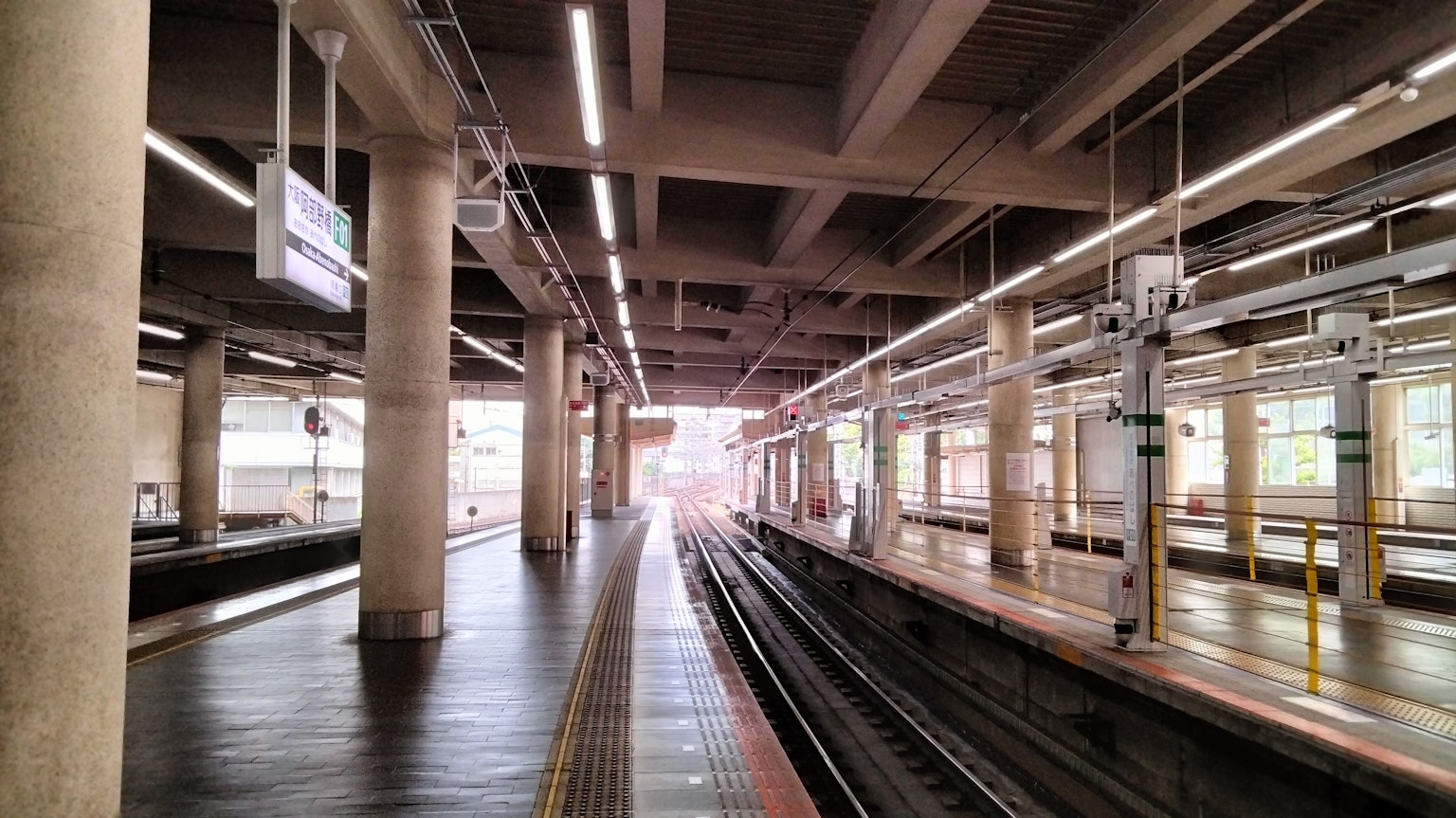 Spacious train station platform with visible railway tracks