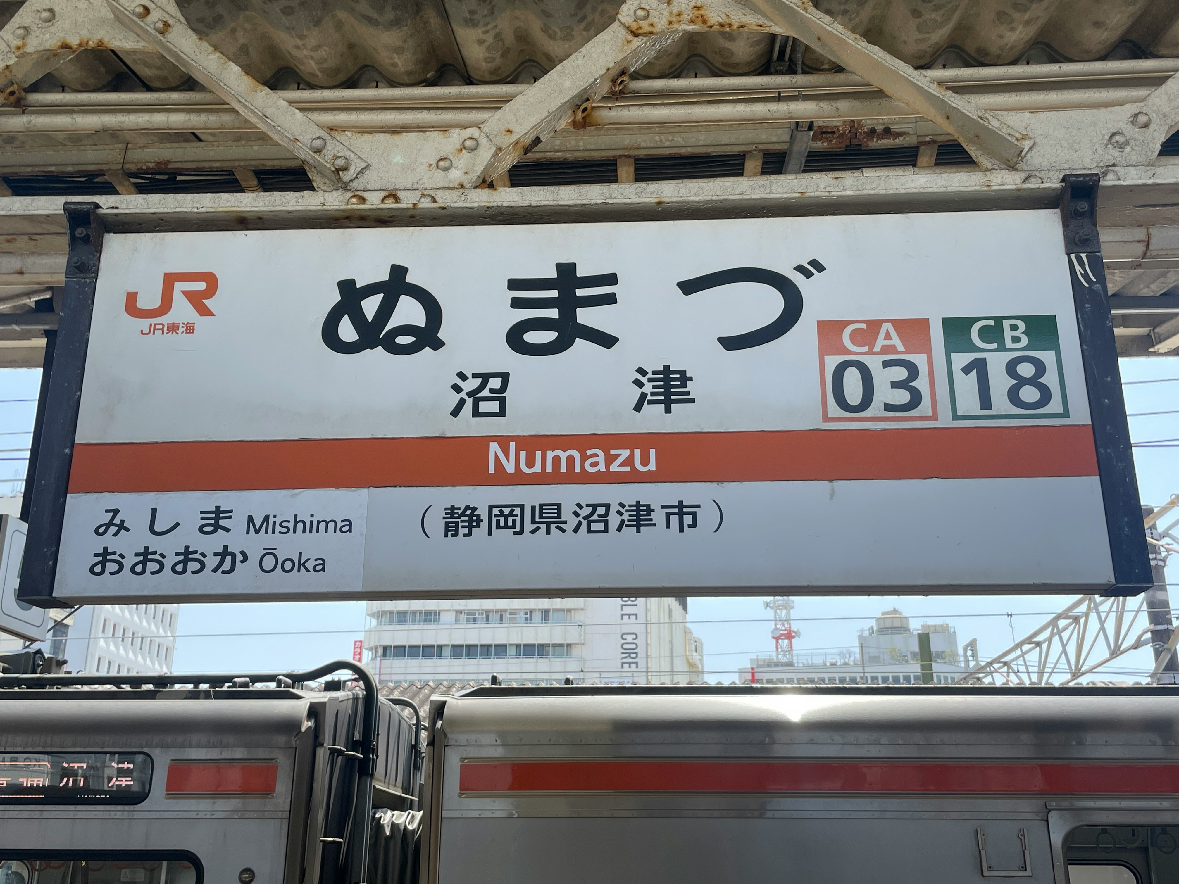 沼津駅の行先表示とJRの駅看板のあるホーム風景