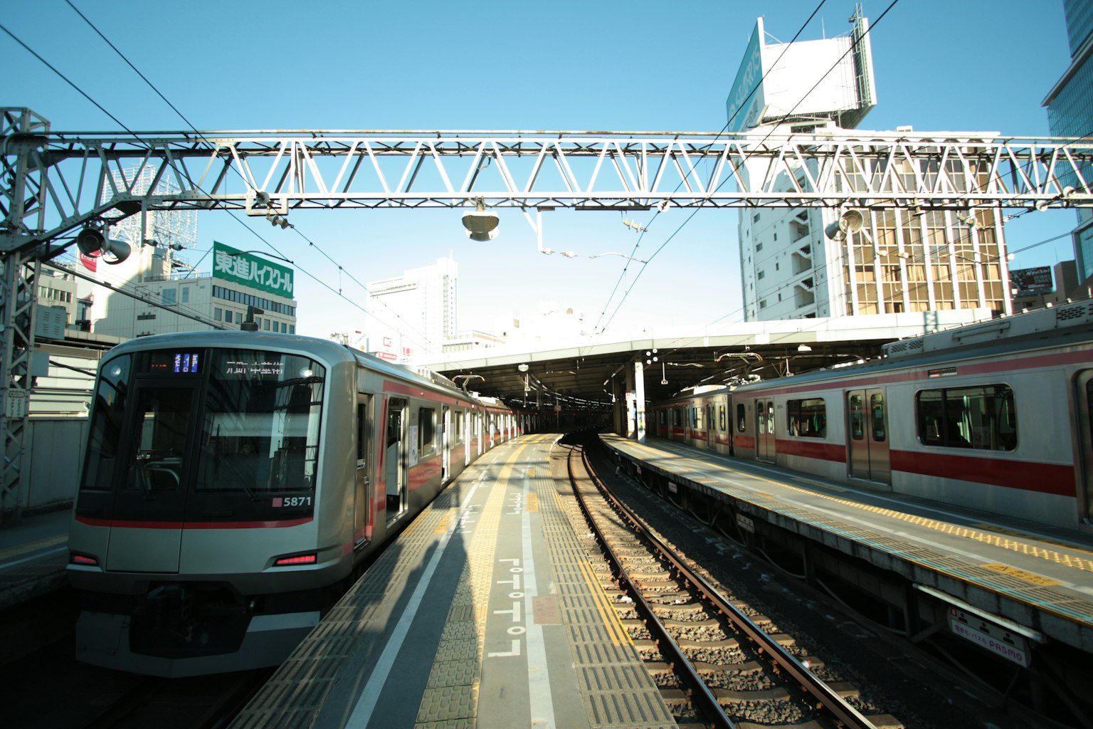 รถไฟที่ชานชาลาสถานีใต้ท้องฟ้าสีฟ้าสดใส