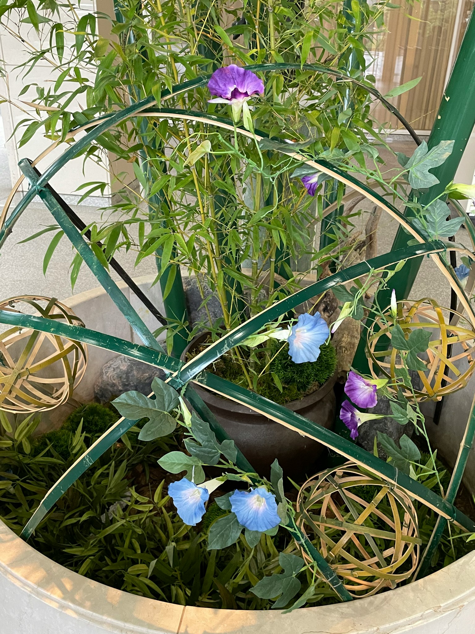 Dekorativer Pflanztopf mit grünen Pflanzen und blauen Blumen