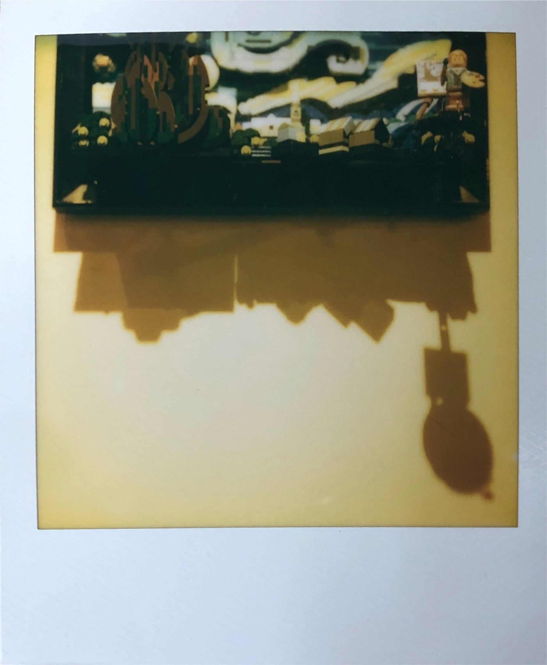 壁に掛かった絵画と影のある室内空間