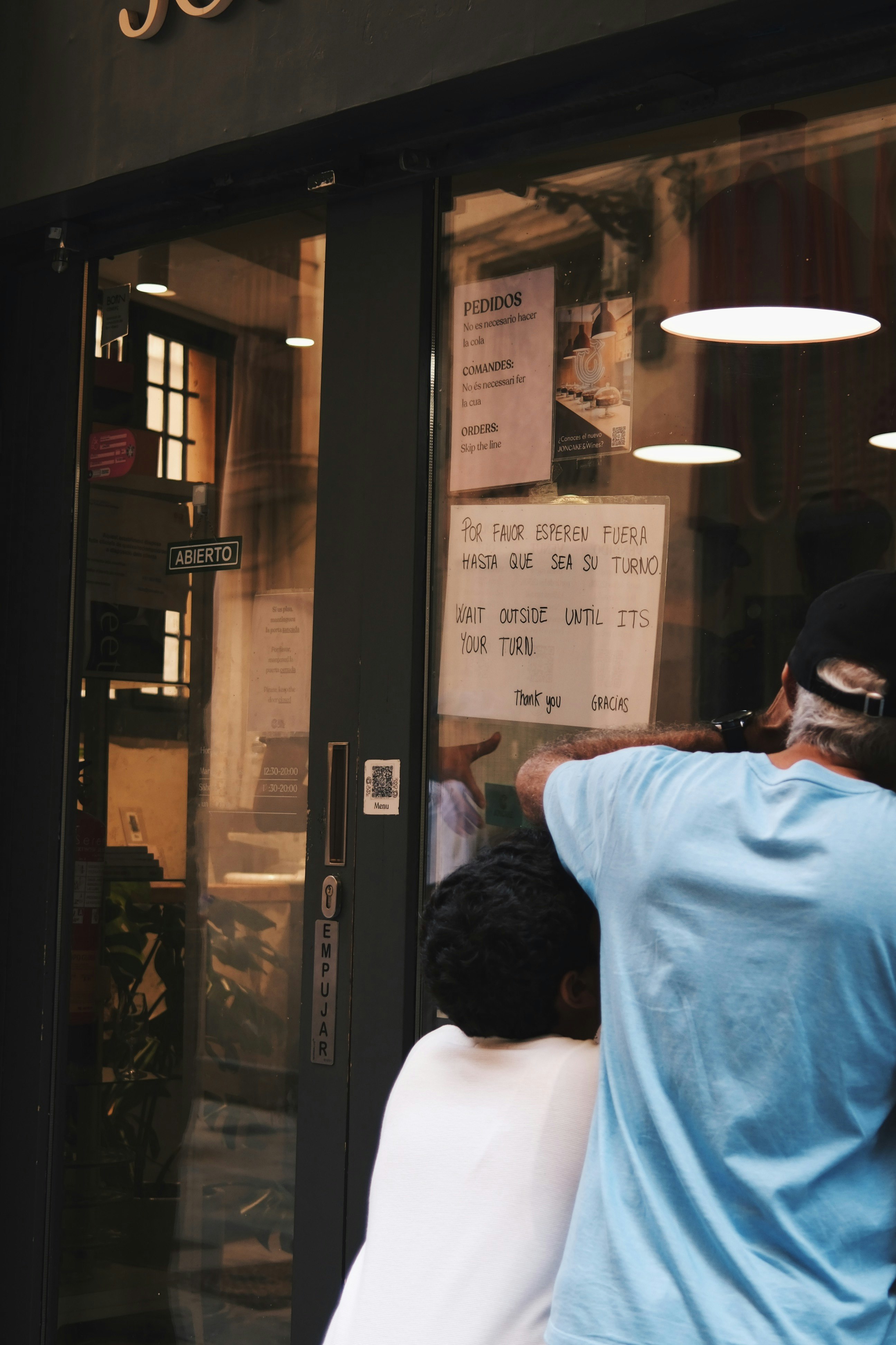 ガラス越しの店内で作業する人々の後ろ姿