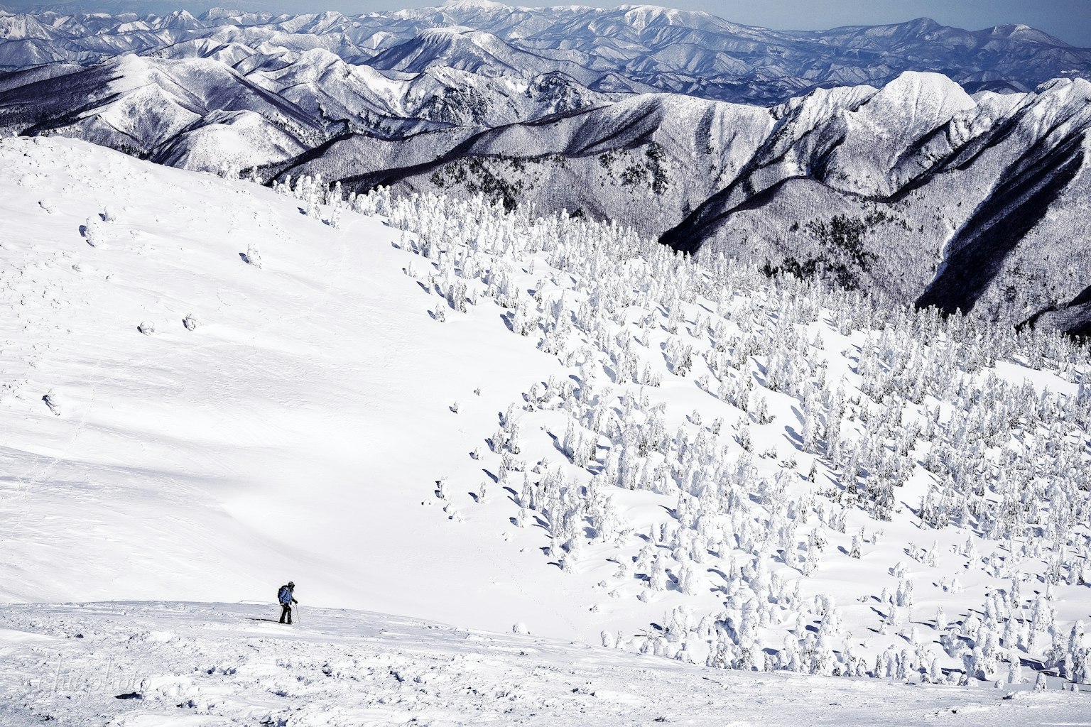 Montañas cubiertas de nieve con un esquiador en primer plano