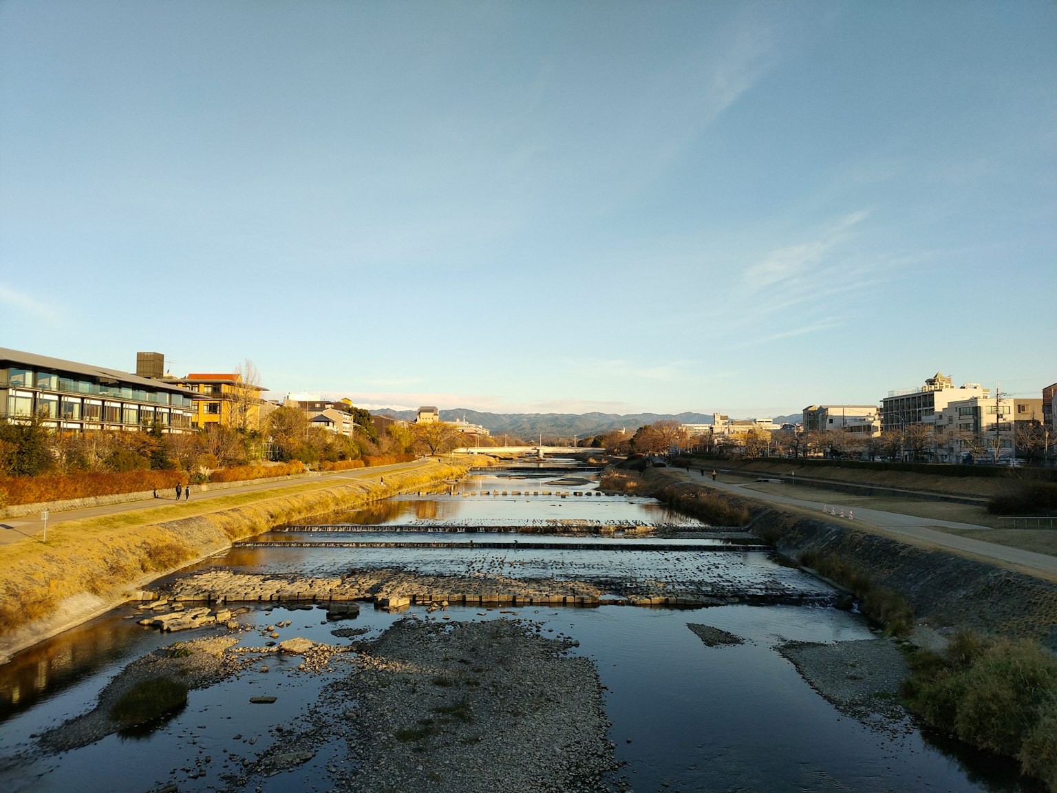 穏やかな川と周囲の建物が映る風景