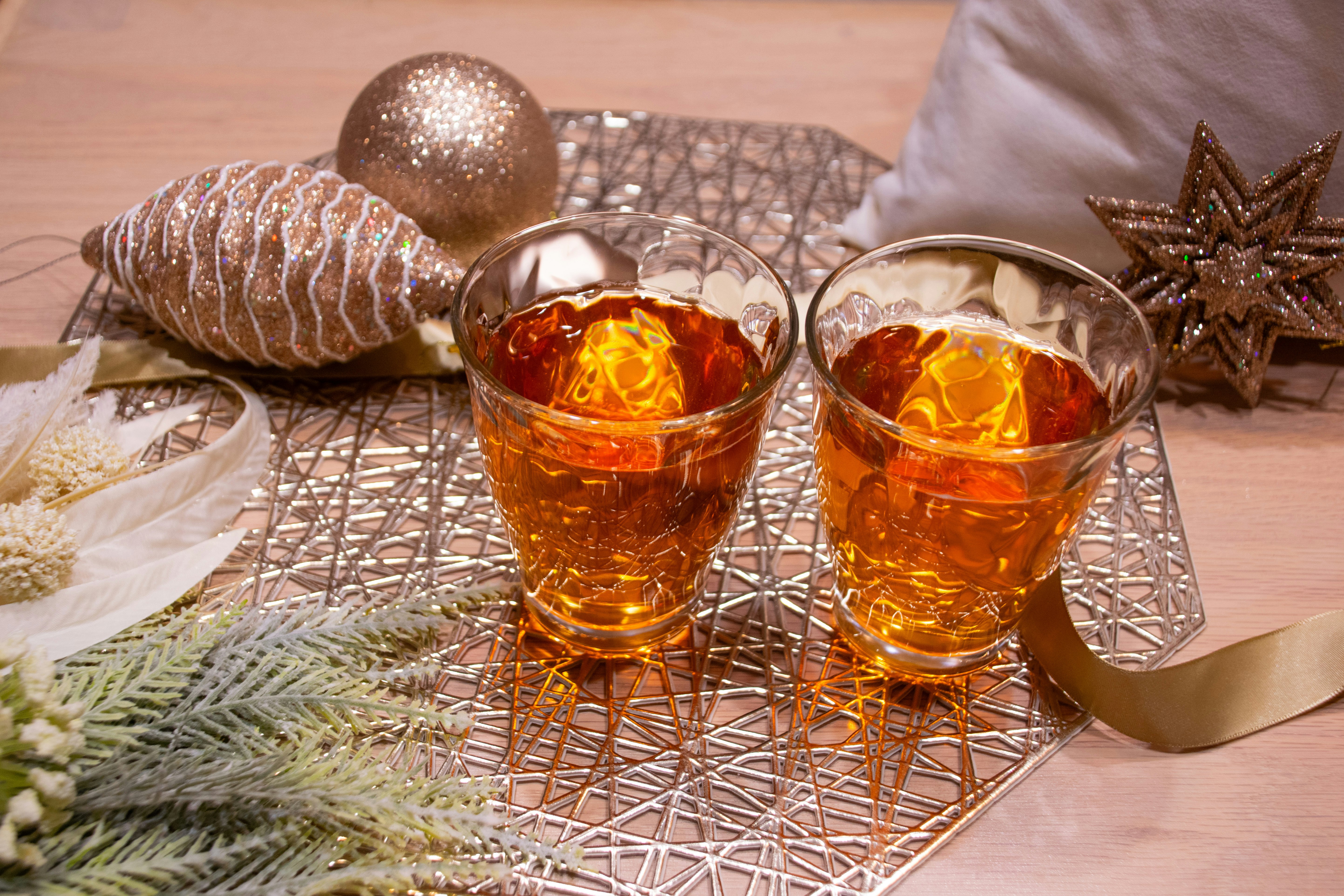 クリスマス風のテーブルに並ぶ琥珀色の紅茶2杯と装飾