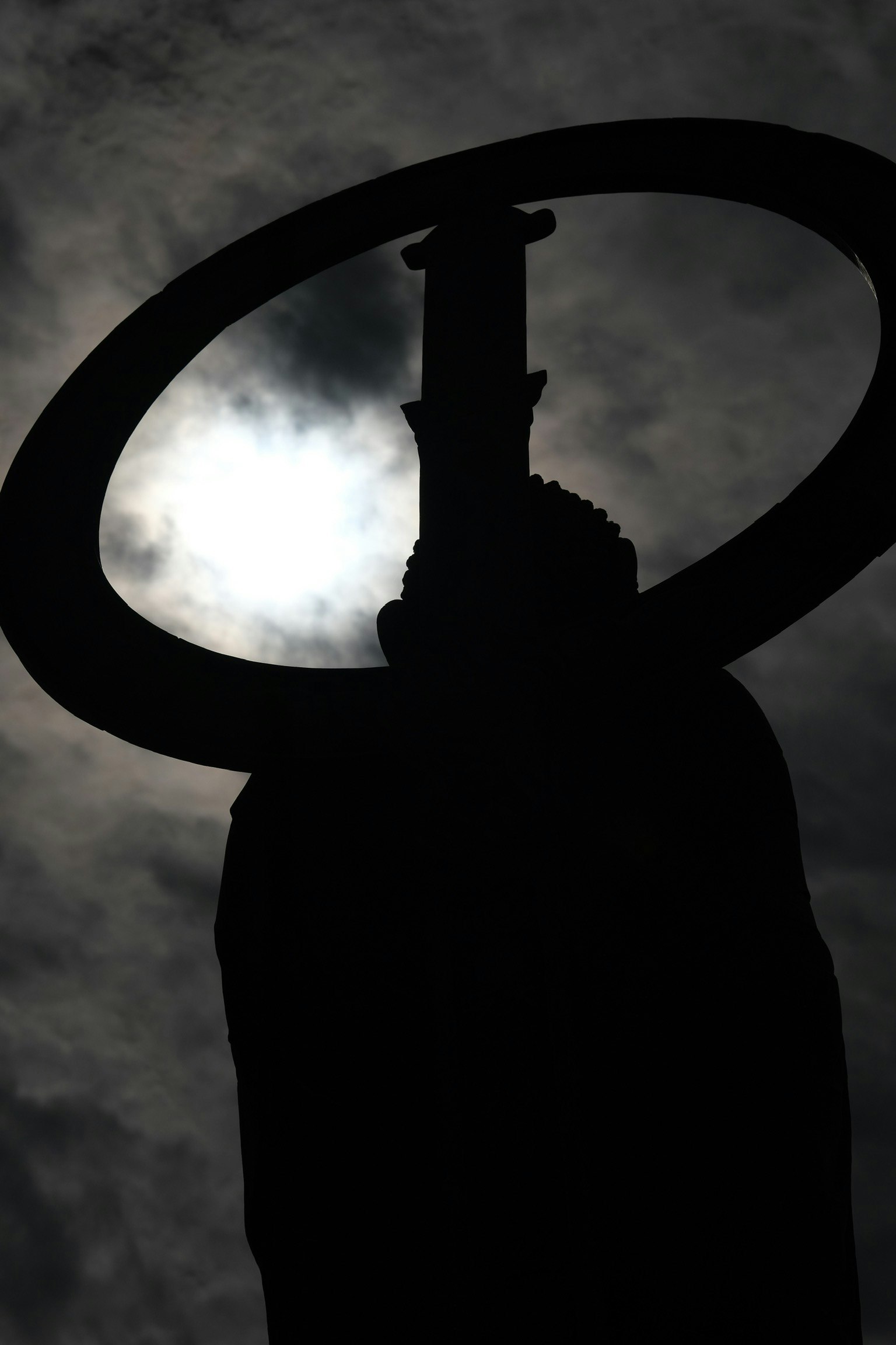 Silhouette d'une statue avec un halo sur fond sombre