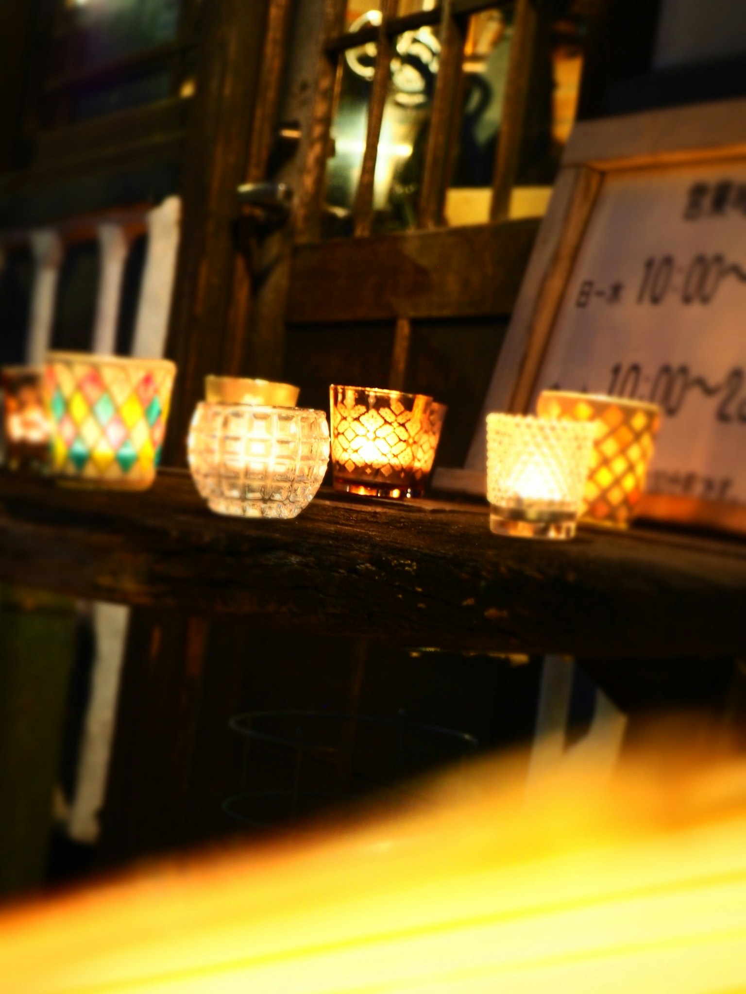 Colorful candle holders arranged on a wooden table