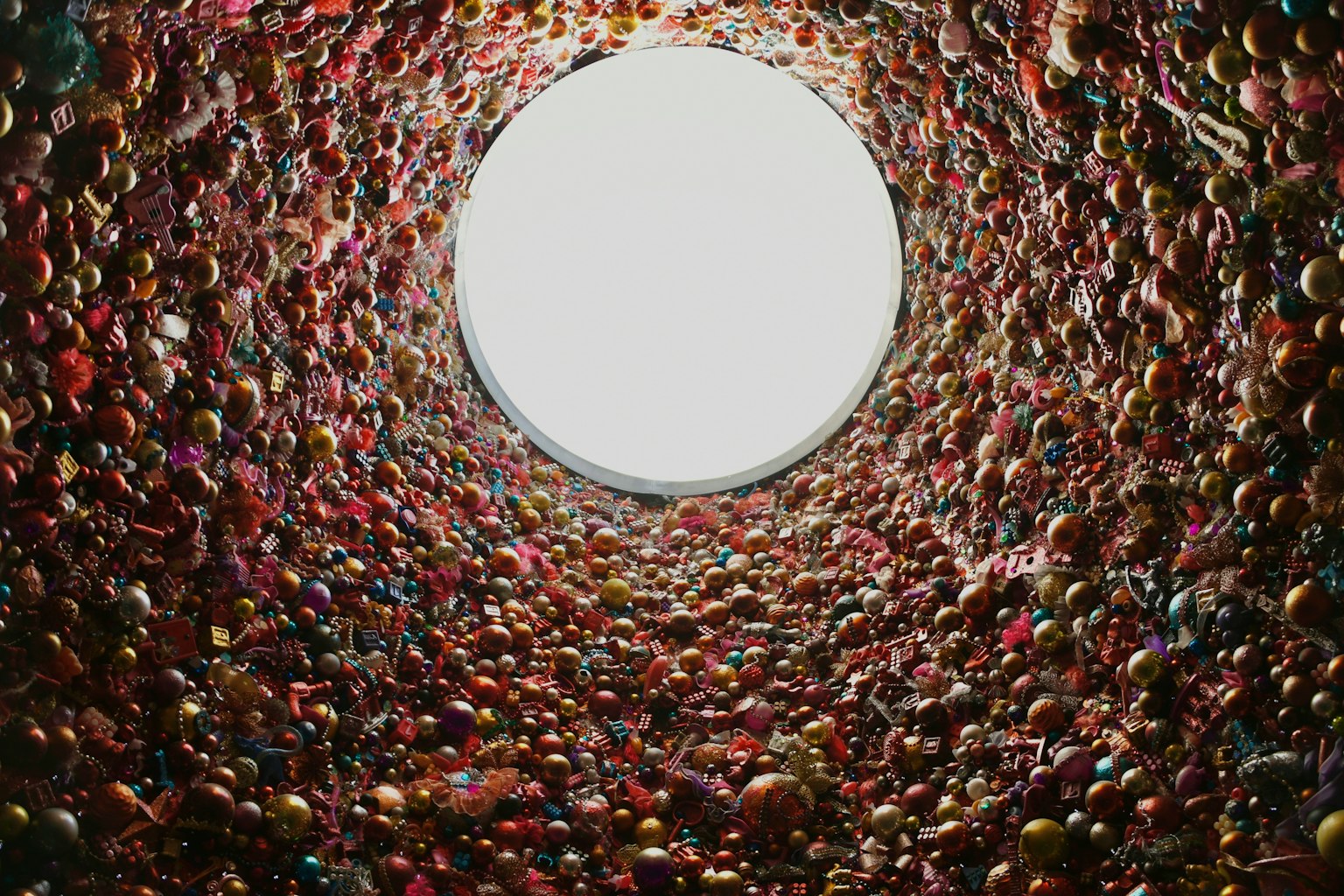 Blick auf eine bunte Wand von innen durch eine runde Öffnung