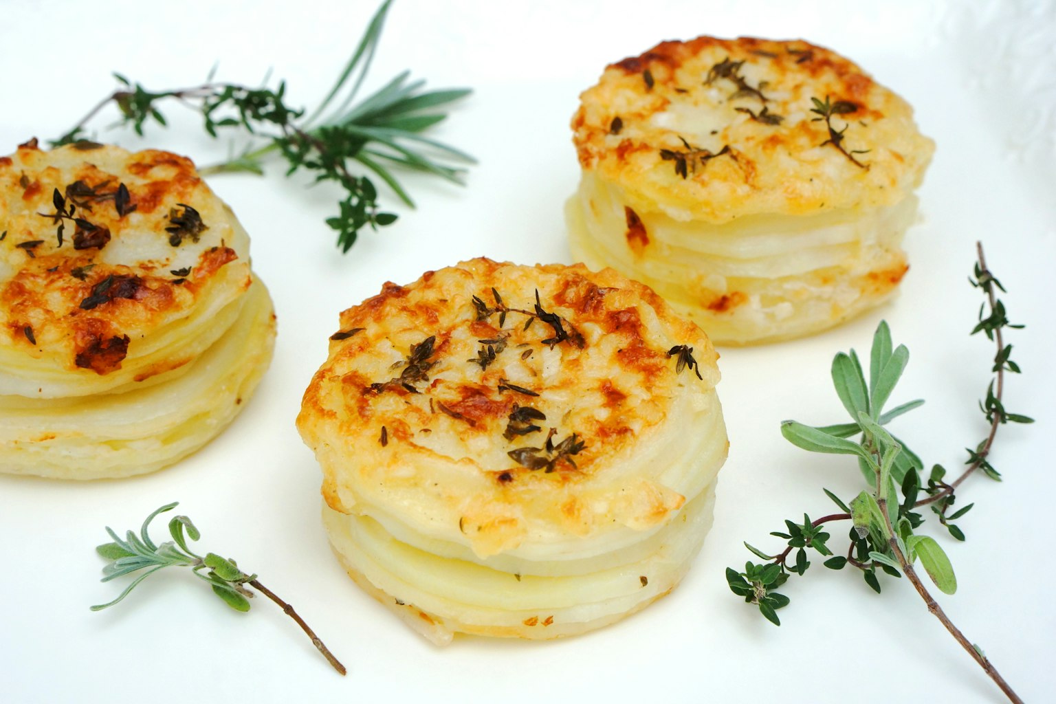 Rondel gratin kentang yang dipanggang dihias dengan herba segar